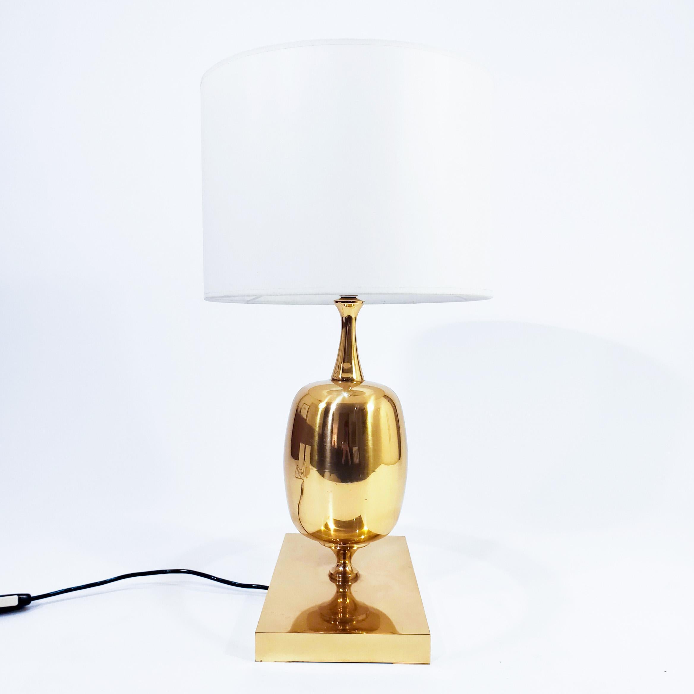 Impressive table lamp from the 70s in the style of Philippe Barbier's designs for Maison Barbier. Egg-shaped body supported on a prismatic rectangular base. The entire structure is made of shiny gilded bronze. In the Hollywood Regency style. Very