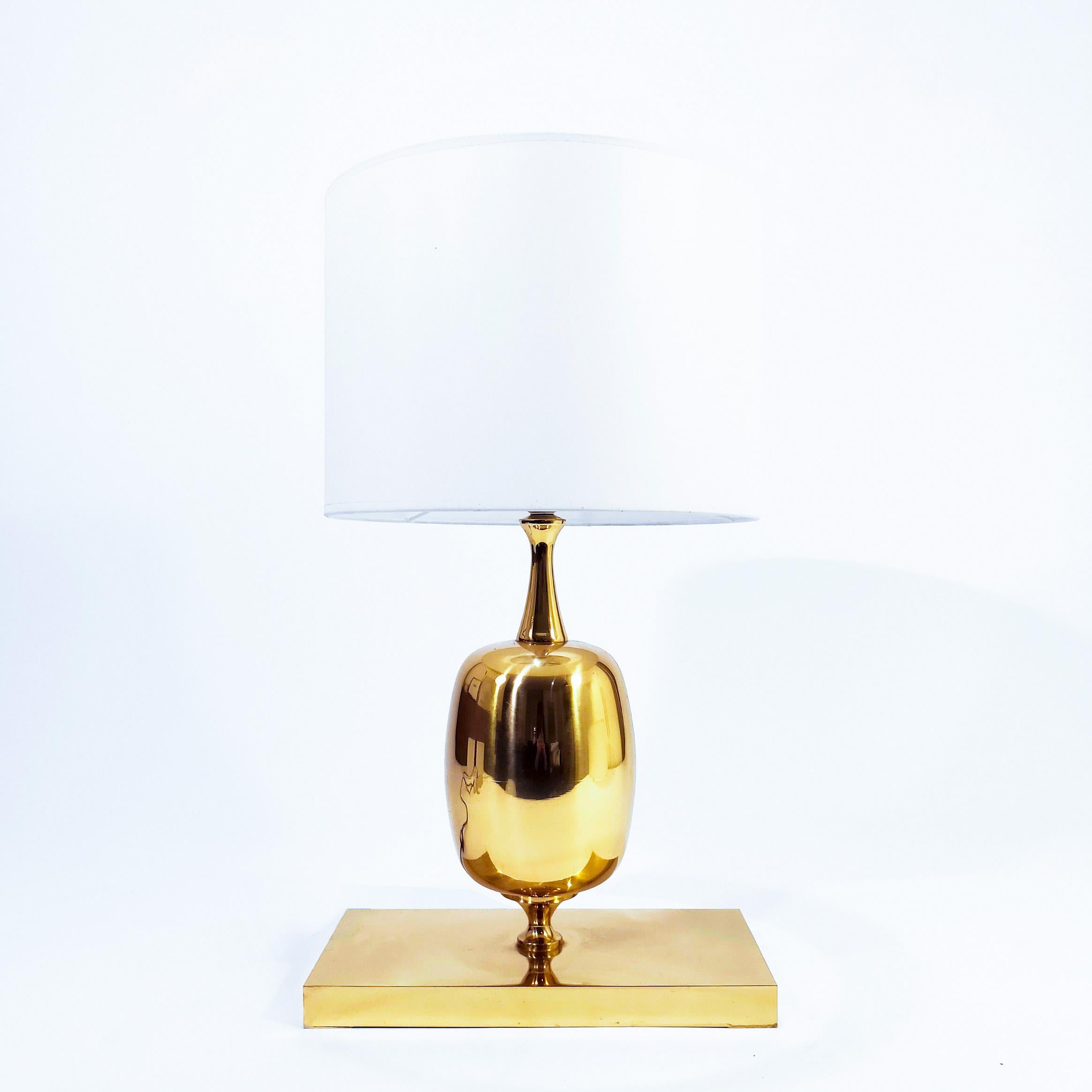 Impressive table lamp from the 70s in the style of Philippe Barbier's designs for Maison Barbier. Egg-shaped body supported on a prismatic rectangular base. The entire structure is made of shiny gilded bronze. In the Hollywood Regency style. Very