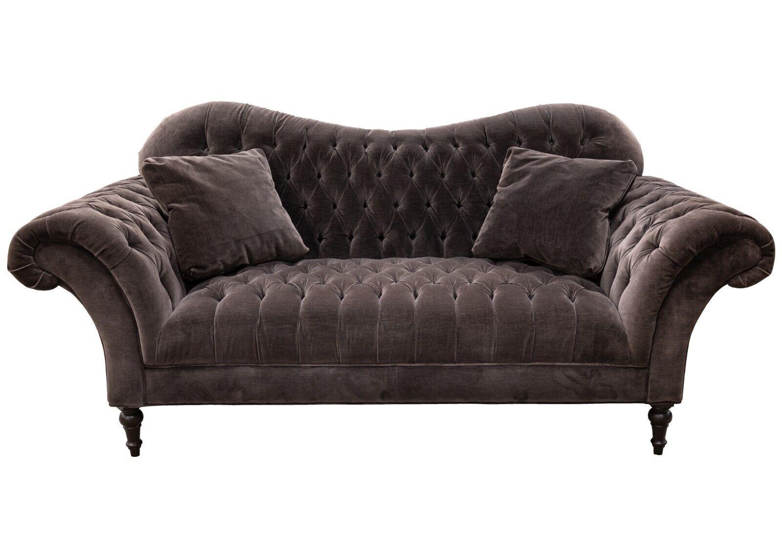 A Hollywood regency style tufted grey velvet sofa. This luxurious piece is iconic of the Hollywood regency style. It is made with a gorgeous grey / violet / slate (depending on the person and lighting) velvet upholstery. This piece has a silhouette
