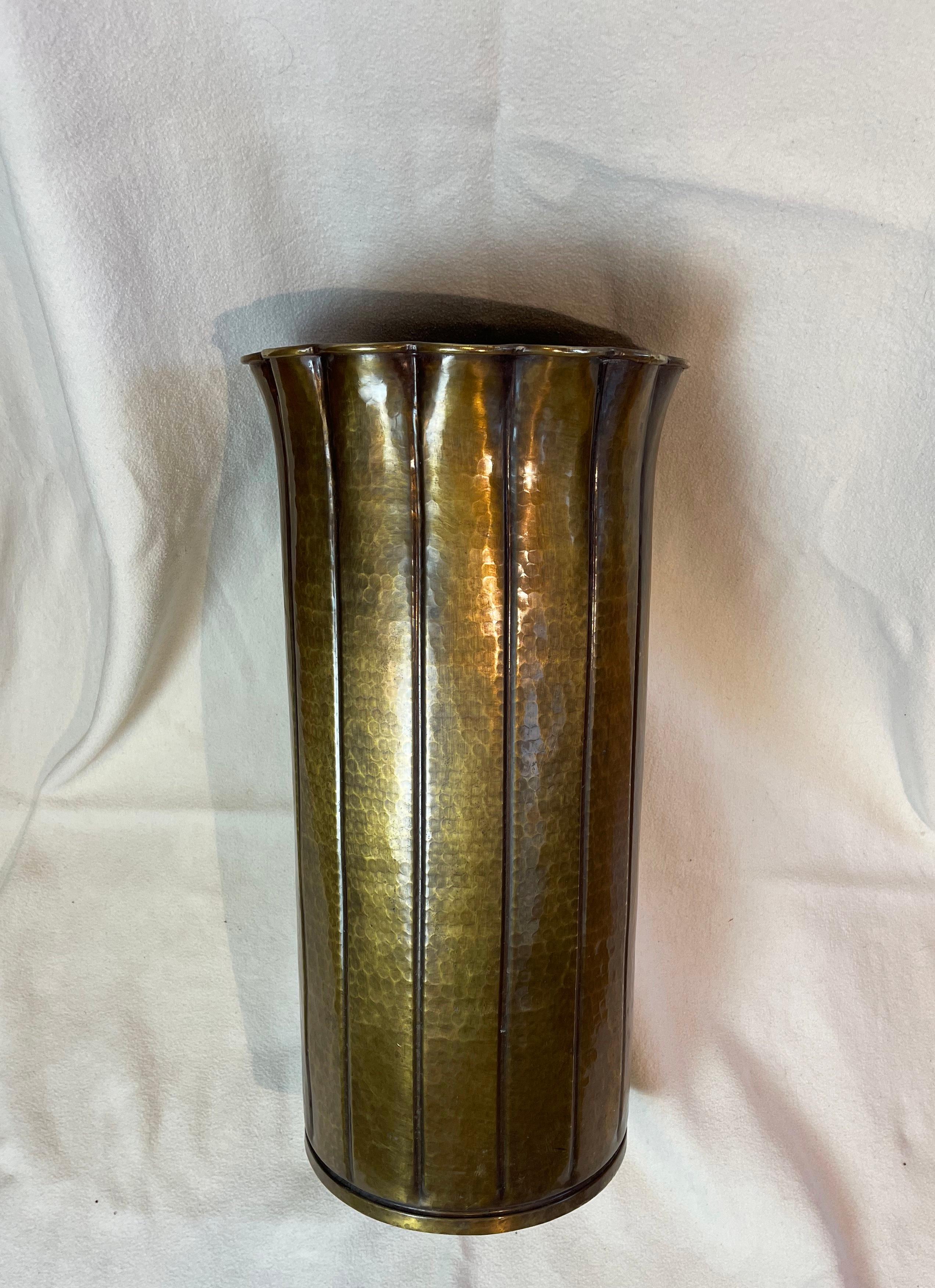 Fantastic umbrella stand in a hammered brass, Hollywood Regency style with a vive of art deco!
Lovely heavy brass with a fluting design which is opening like petals at the top.
The inner base gains weight through a cement cast layer.
Comes with a