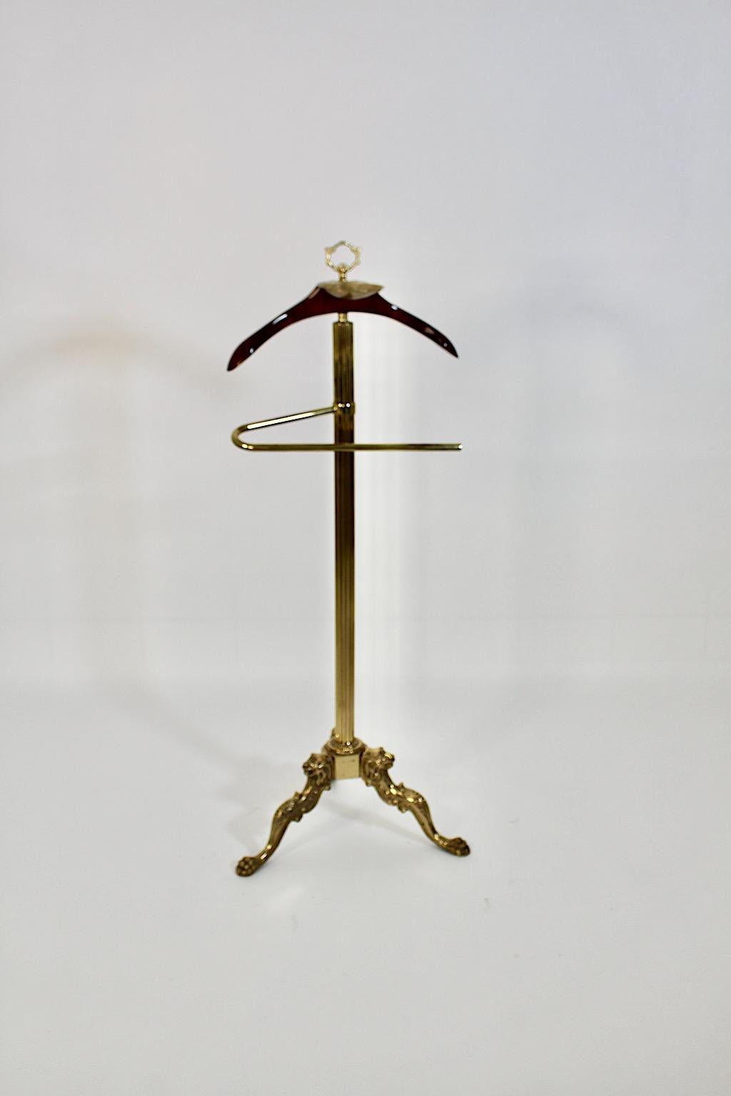 Hollywood Regency style vintage three legged valet or coat rack from brass and beech 1970s Italy.
An amazing valet or coat rack from brass and beech with beautiful details.
This three legged valet shows a body from brass while the hanger was made