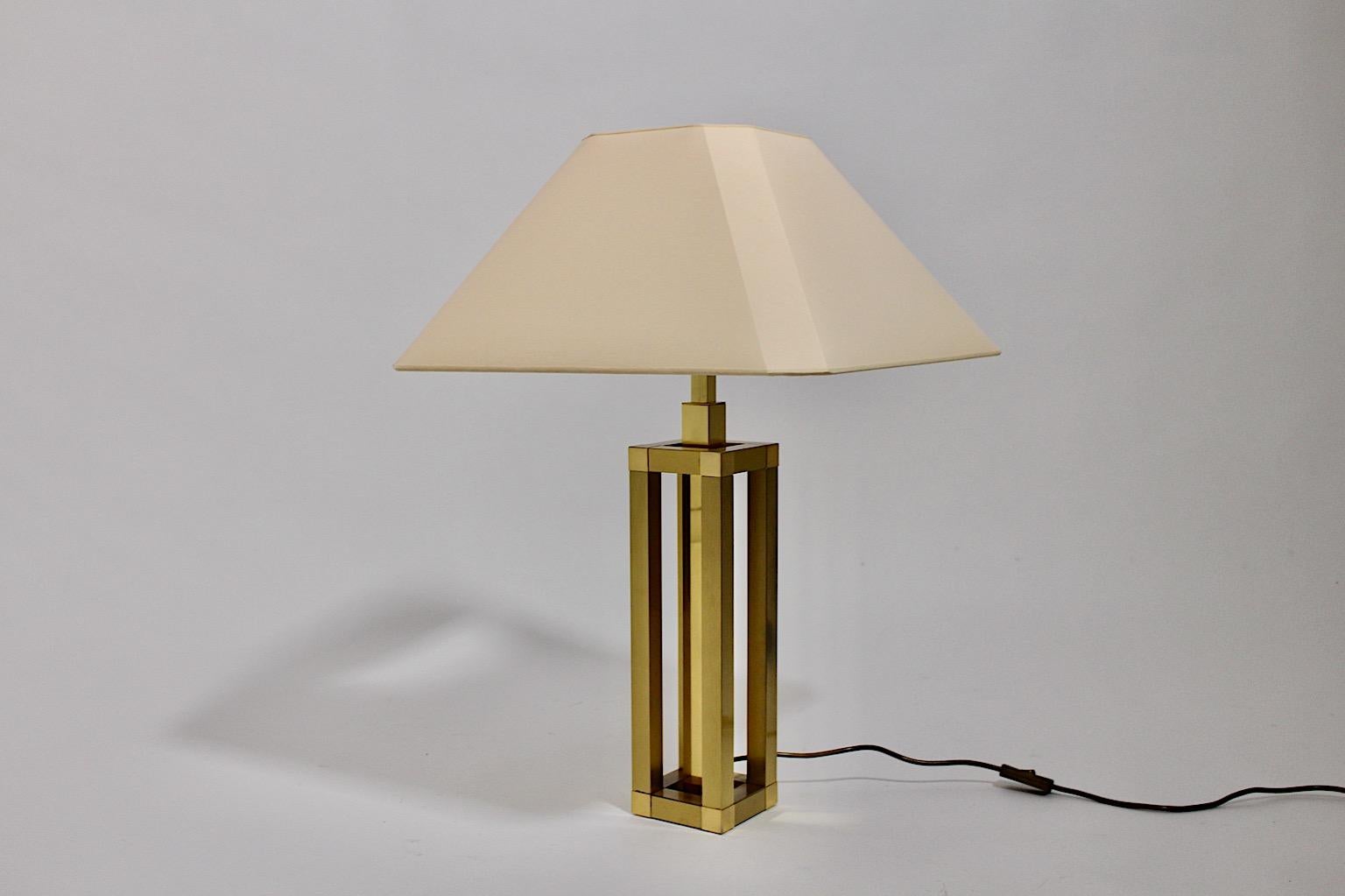Hollywood Regency style vintage table lamp from brass, which design is very similar to Romeo Rega design Italy 1970s.
While the table lamp base shows a brass construction in geometric shape, the renewed lamp shade shows an ivory color tone. The