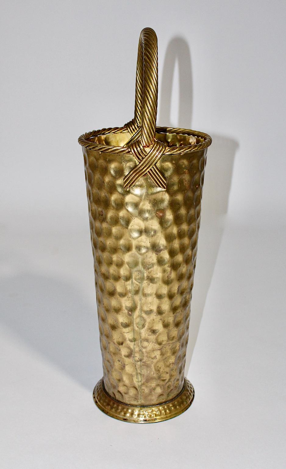 A fantastic Hollywood Regency style vintage brass umbrella stand, which was designed and made in Italy 1970s.
The handmade umbrella stand was made out of hammered brass.
The handle looks like a twisted cord and is decorated on each side with two