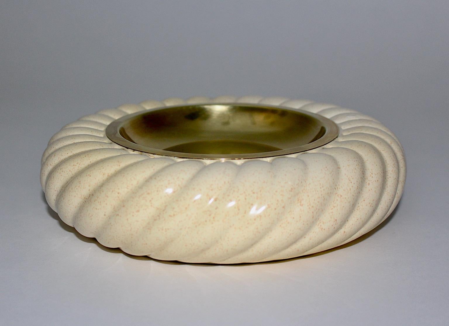 Hollywood Regency Style vintage bowl or catchall from ceramic and brass by Tommaso Barbi, Italy, 1970s.
A sophisticated Italian bowl or catchall worked out from white twisted ceramic with brass center by Tommaso Barbi for Ceramichi for Tommaso