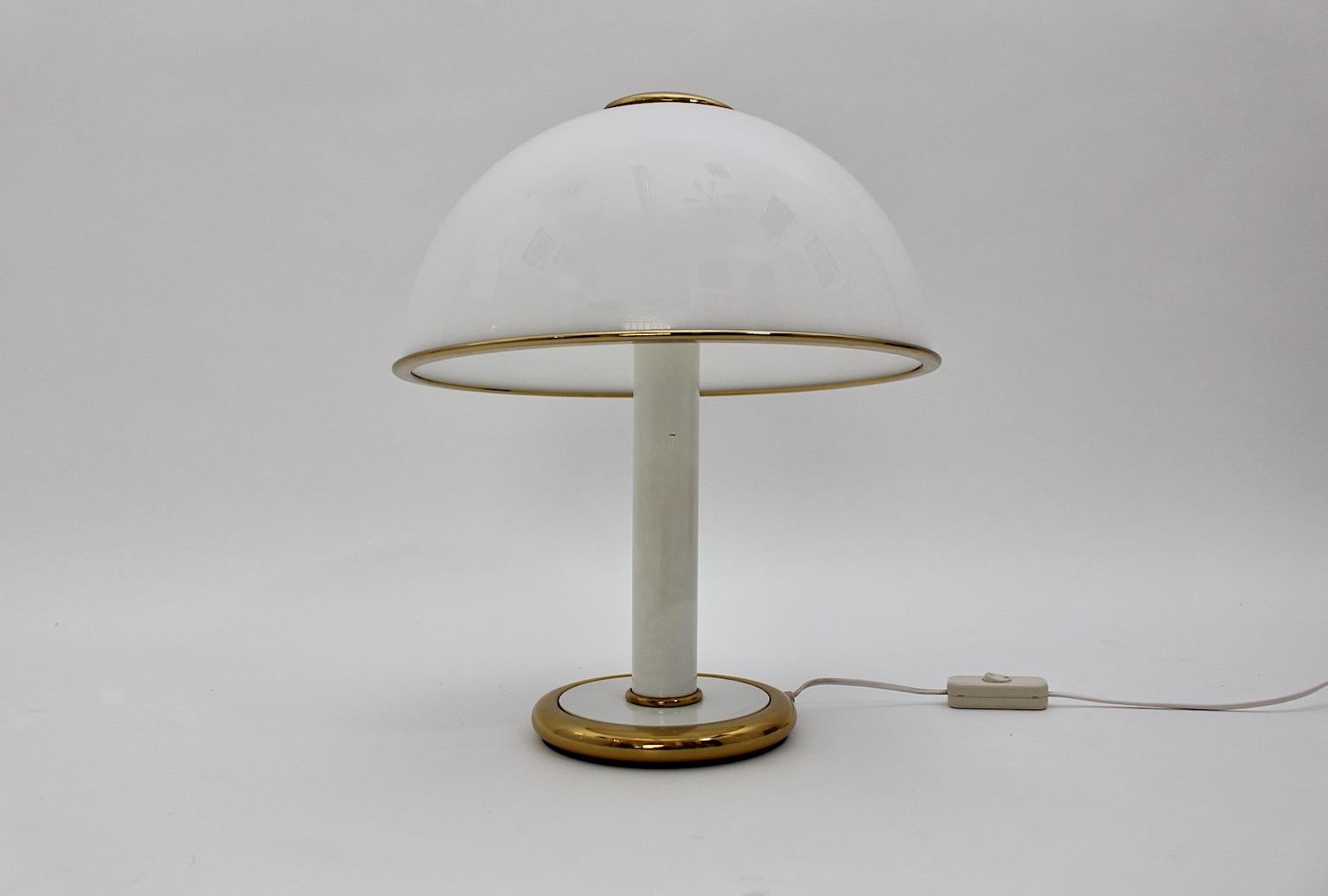 Hollywood Regency Style vintage table lamp from white glass and brass details dome mushroom like 1970s.
A beautiful vintage table lamp with a white glass dome and brass details mushroom like.
This stunning table lamp features a clear vibe through