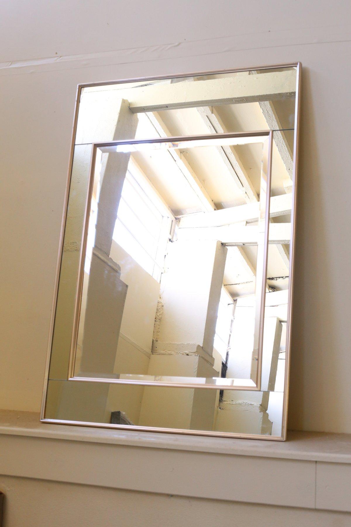 Hollywood Regency style wall mirror designed by LaBarge. Designed in the 1980s with mirrored panels encased in a rose gold tone reeded frame surrounding an inset bevelled mirror. This mirror adds presence and glamour to any room.