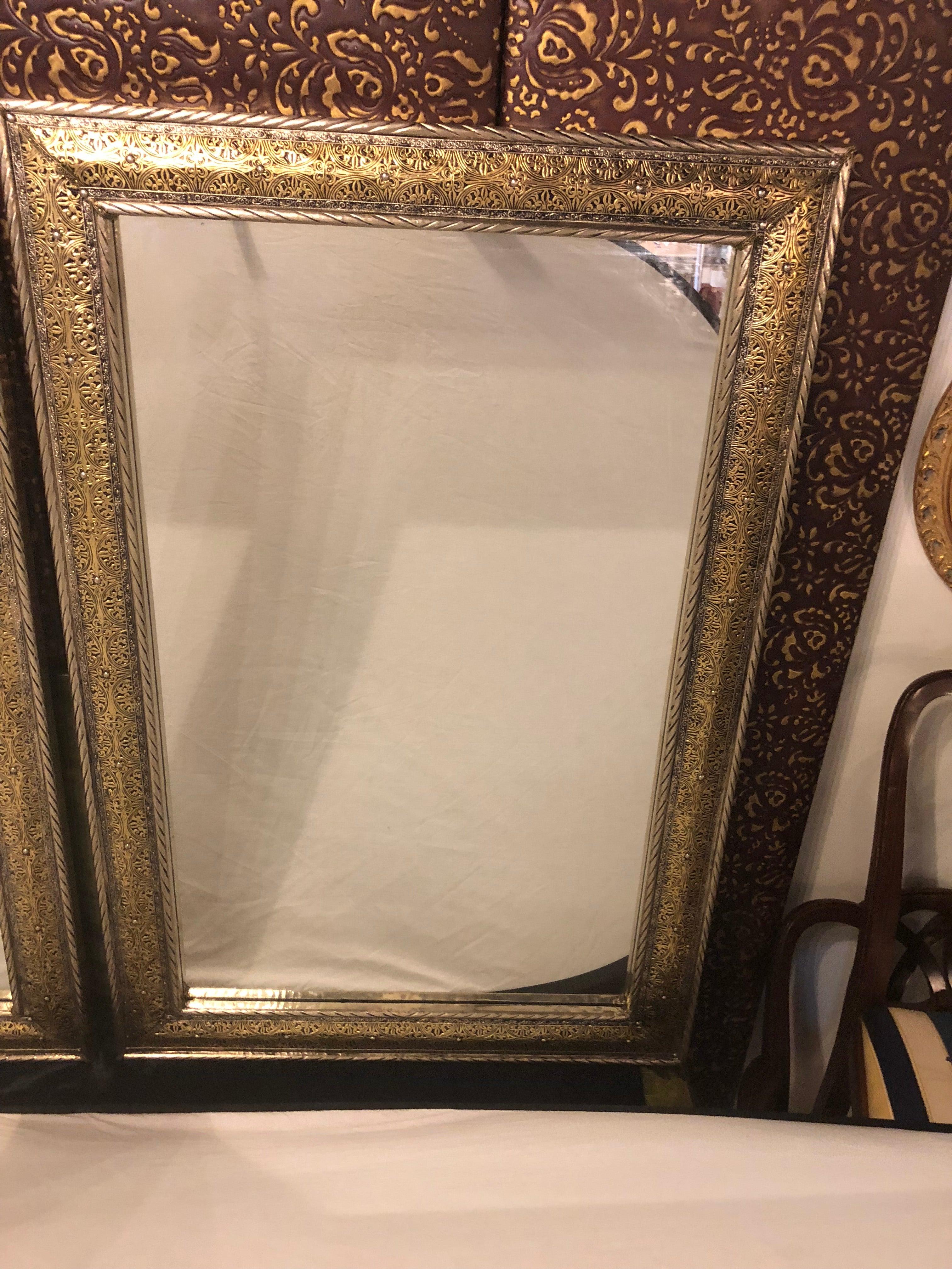 Ein beeindruckendes Paar großer Spiegel im Hollywood-Regency-Stil. Die Spiegel verfügen über einen außergewöhnlichen Rahmen aus goldenem Messing auf silbernem Metall, der in filigraner Handarbeit gefertigt ist. 

Kann als ein Stück gekauft