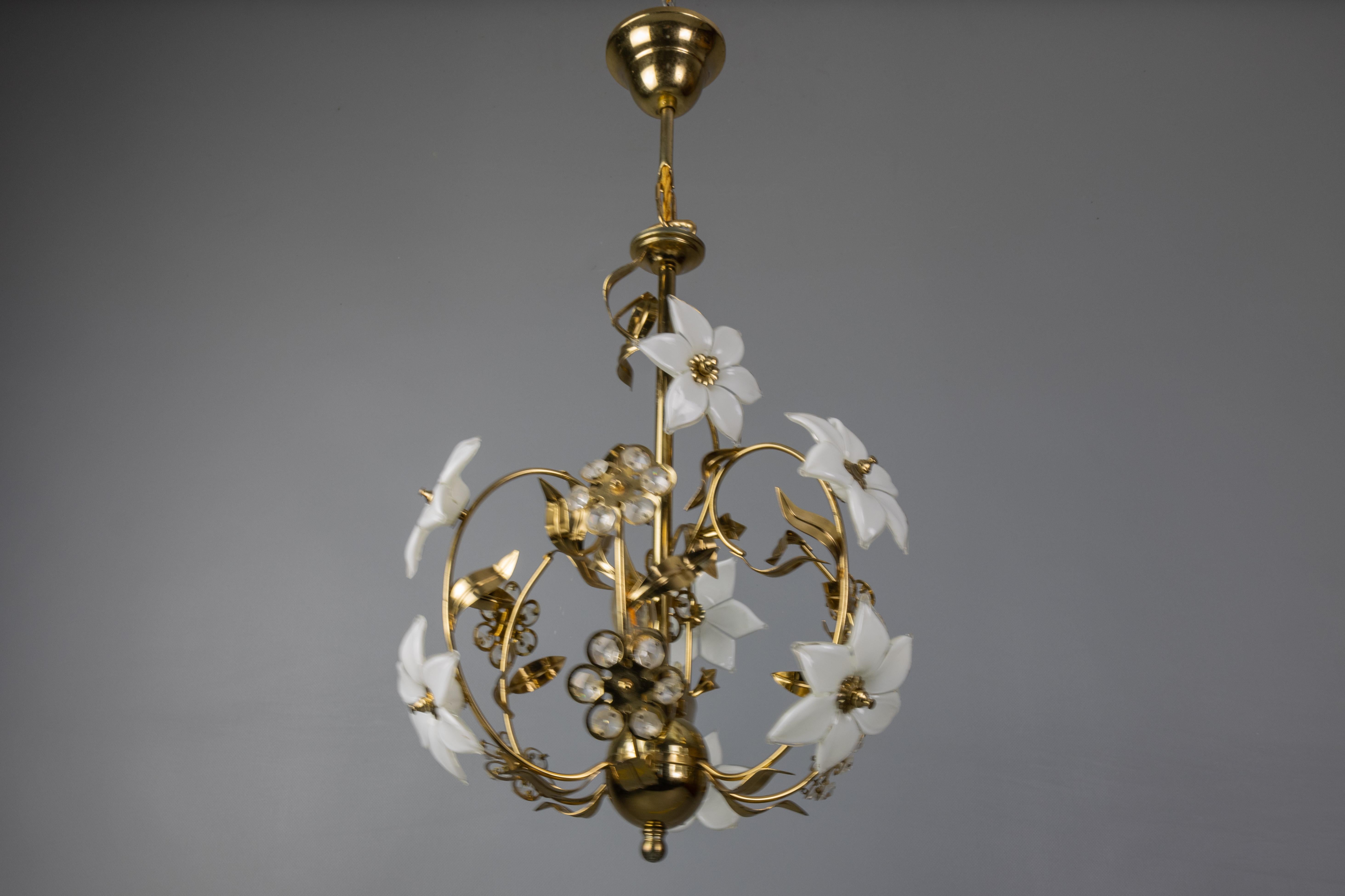 Lampadario a fiore in metallo, vetro bianco e cristallo in stile Hollywood Regency, Italia, circa 1980.
Questo splendido lampadario a due luci italiano presenta un design a gabbia d'uccello con una struttura in metallo color oro circondata da fiori