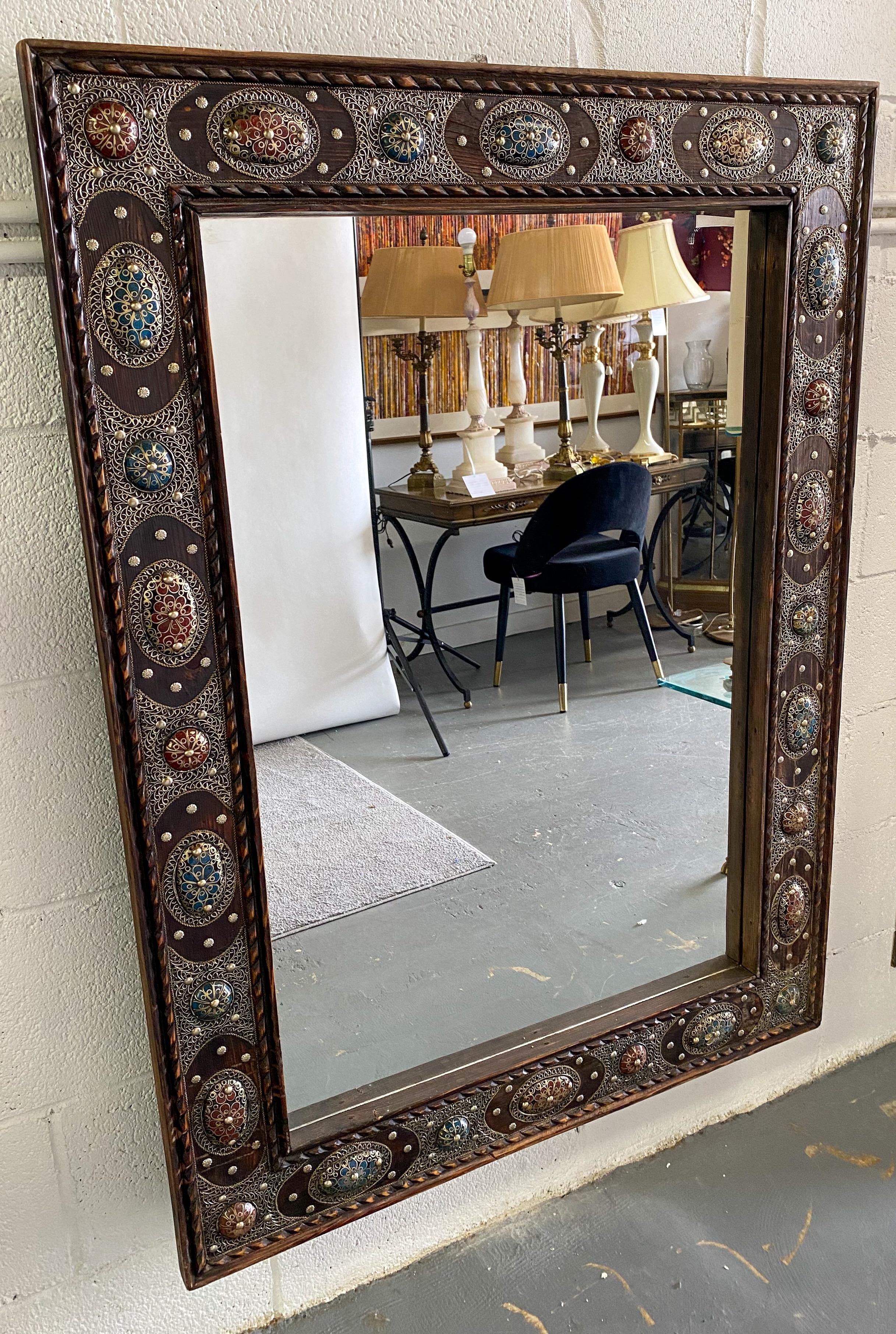An impressive piece that speaks equally to nuanced artisan craftsmanship and bold imagination, this Hollywood Regency style mirror is a sumptuous and entrancing home decor item that will elevate the style of any room. Handcrafted from genuine cedar
