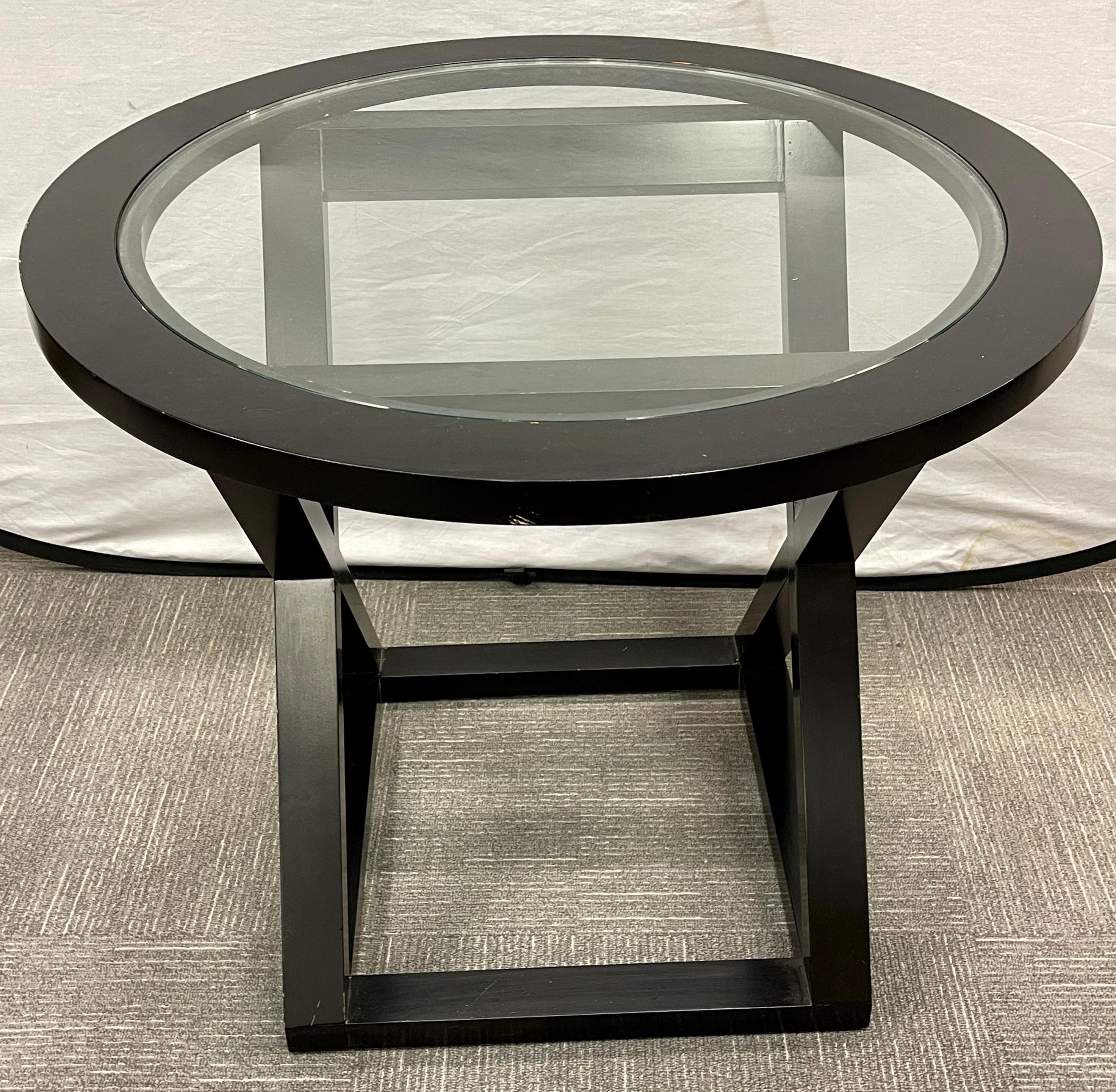 Mesa de centro o auxiliar con base en X estilo Hollywood Regency. La fina base de madera maciza soporta una tapa de cristal transparente.