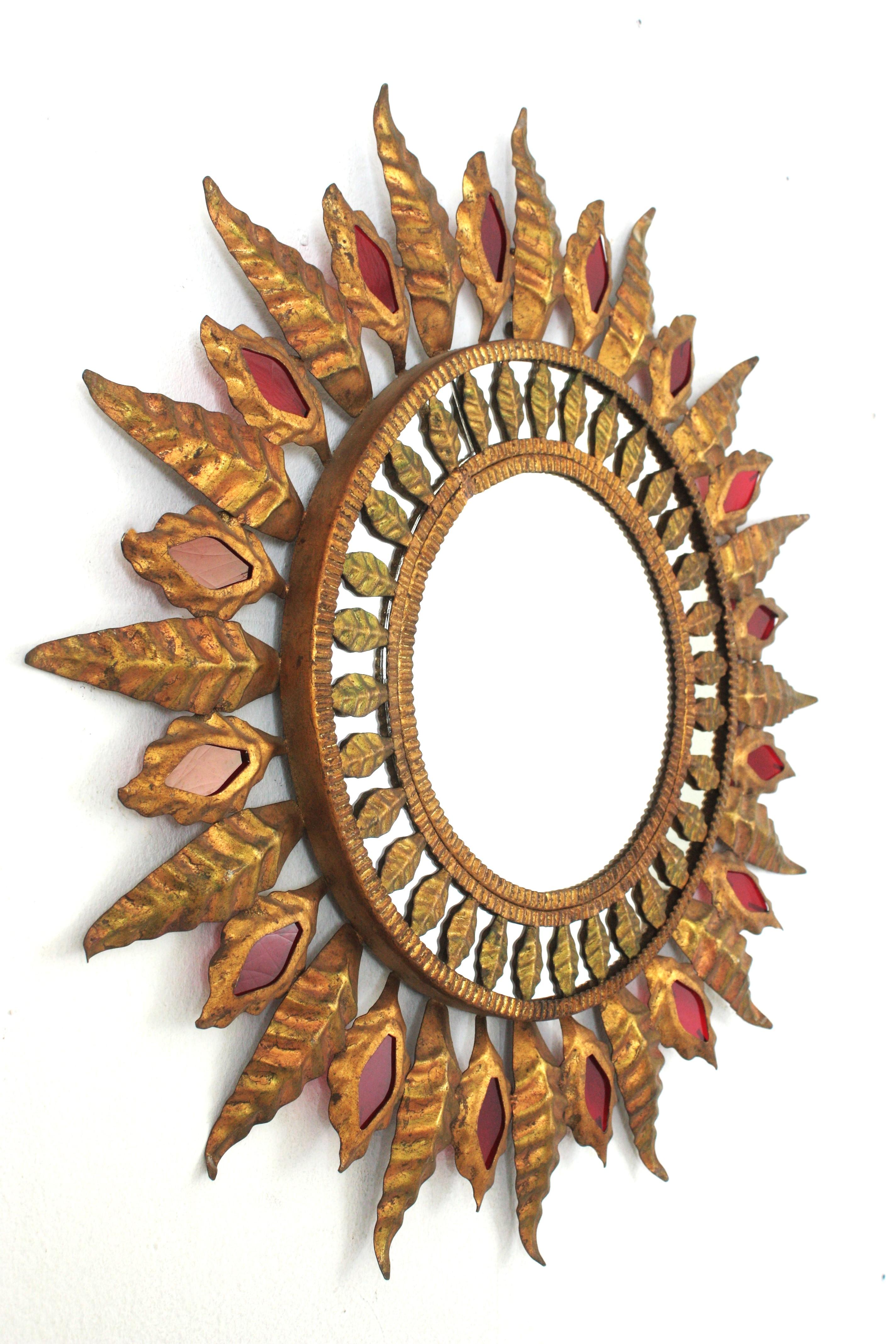Spanish Hollywood Regency Sunburst Mirror in Gilt Metal and Red Glass Detail, 1950s For Sale