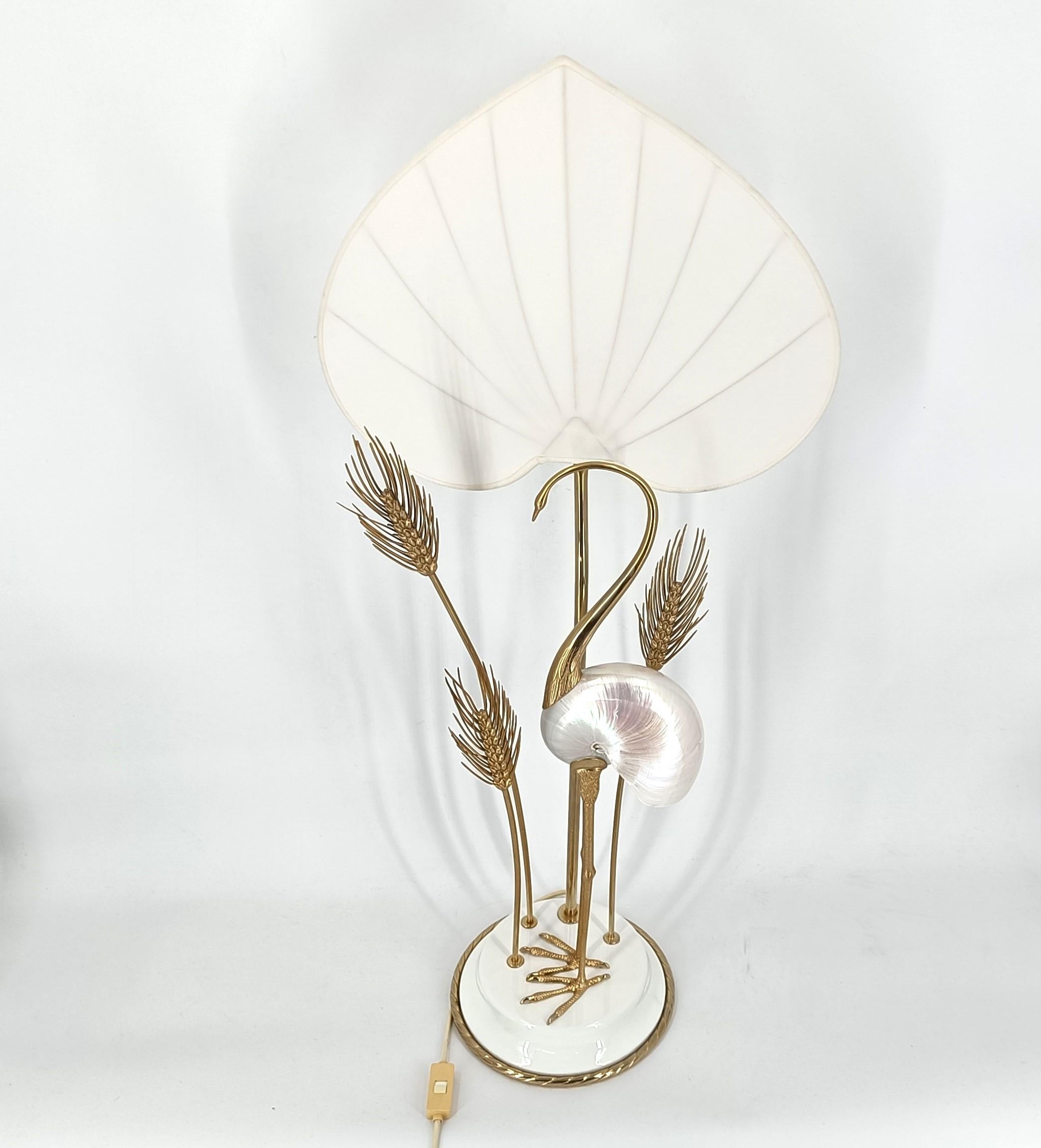 Mid century art table lamp crafted by Antonio Pavia, consisting of a ceramic foot, sculpted brass crane bird and water plants, with a purpose made linen shade. The center piece of this lamp is ofcourse the mother of pearl nautilus.

Fantastic