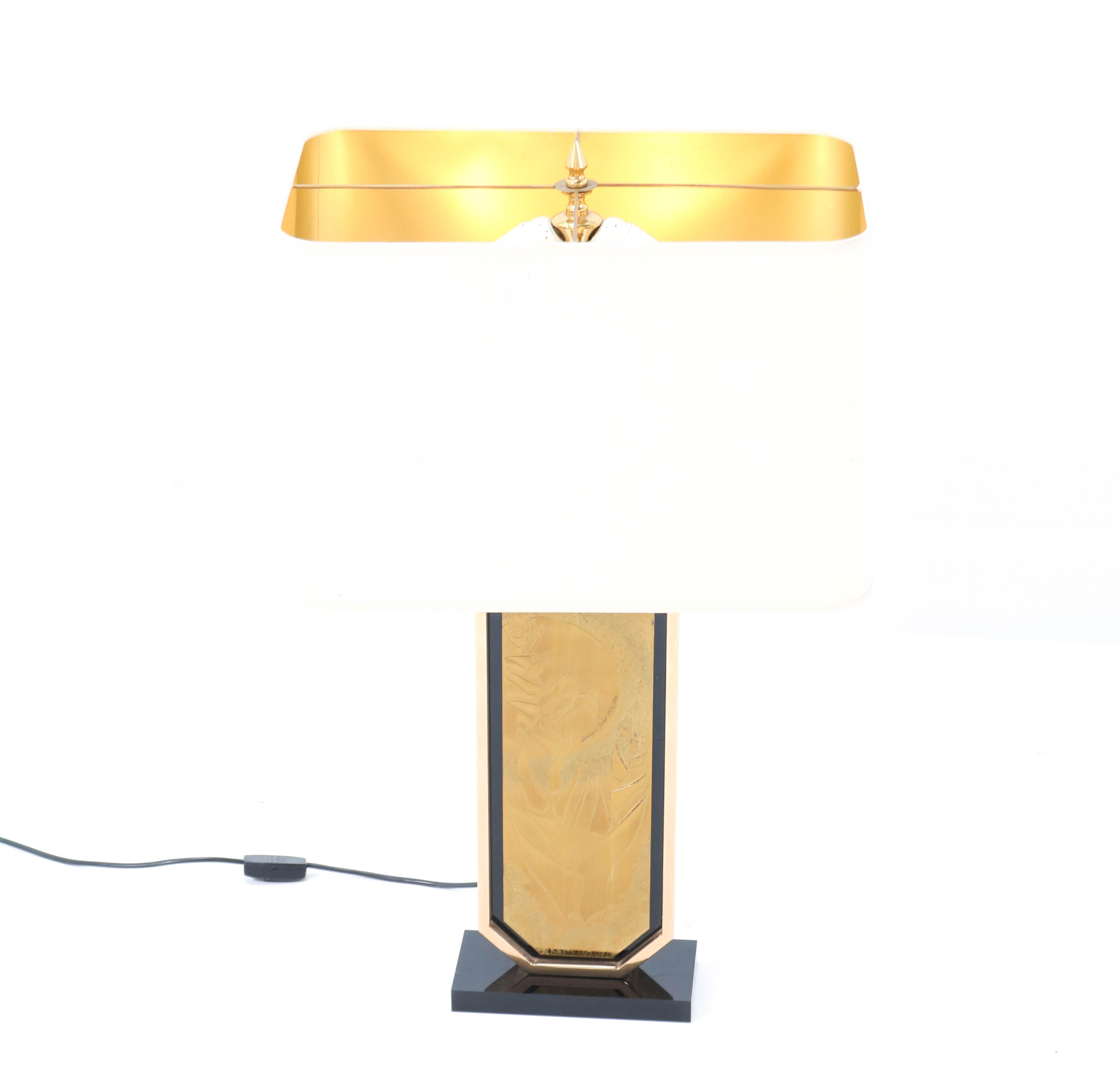 Wonderful Hollywood Regency table lamp.
Design by George Mathias for Designo Mahó.
Striking Belgium design from the 1970s.
Gold plated etched brass base with black lucite details.
Original shade.
Marked and numbered 167/250.
In very good
