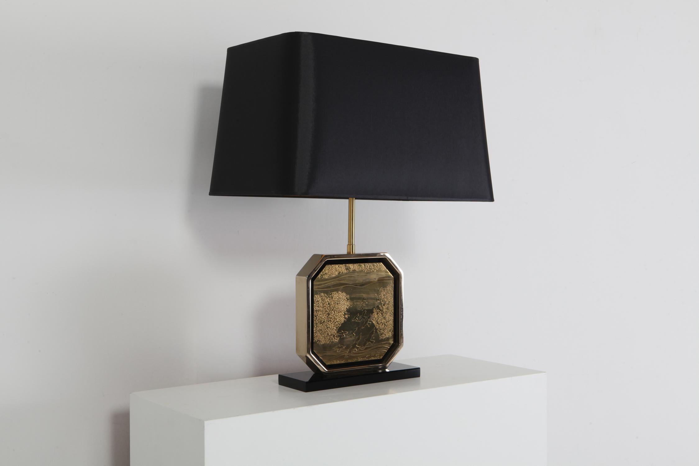 Glam table lamp in Hollywood Regency style.
Luxury piece with a 24-Karat gold plated brass frame and a brass etched artwork by maho in centre.
Beautiful black silk shade with gold lining.