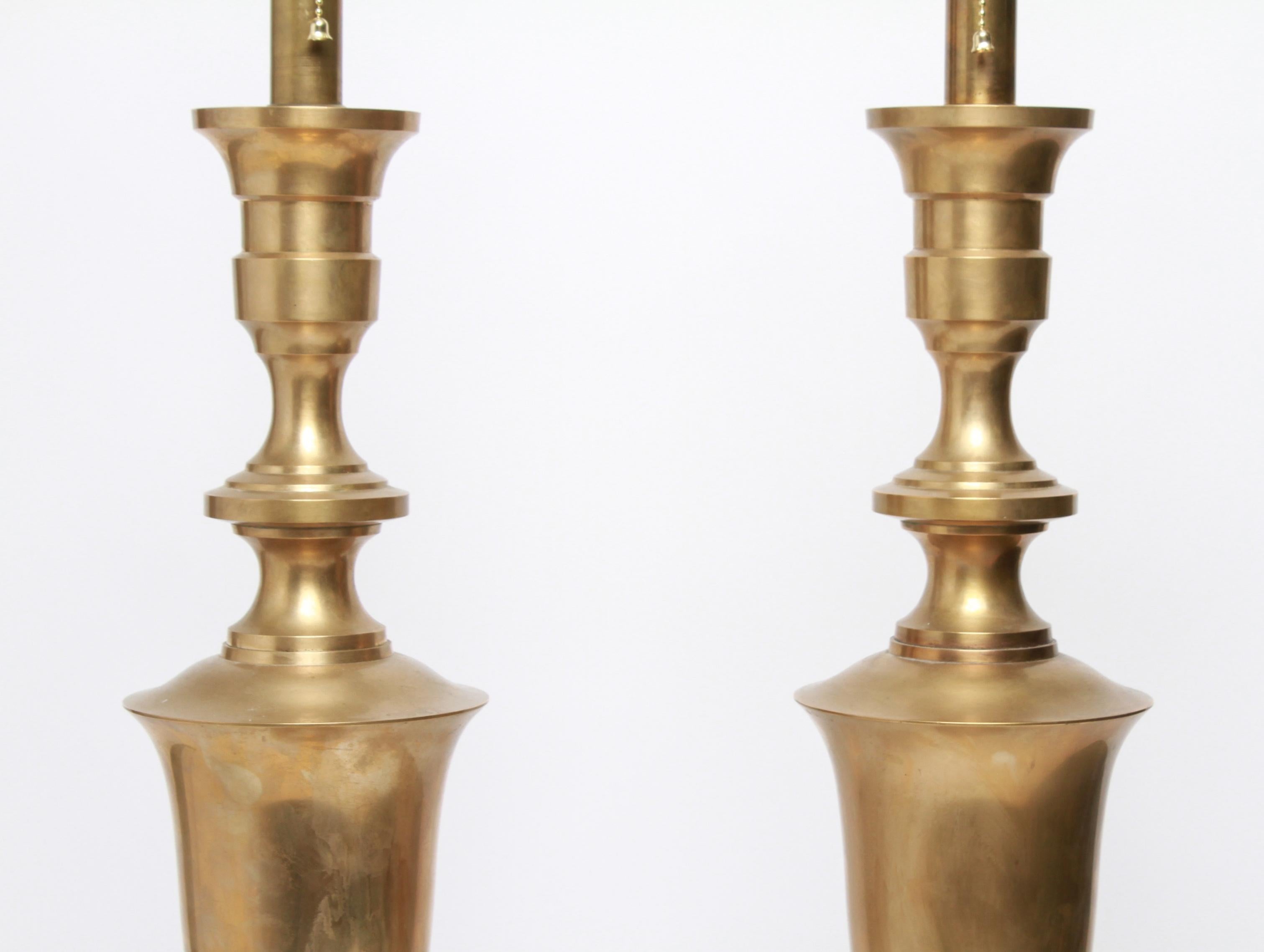 Pair of Hollywood Regency tall brass table lamps, stylized urn body on bell form base. Measures: 43.5