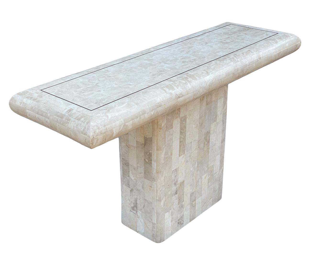 A vintage stone veneer console table from the 1980's. It features off white colored stone with inlayed brass detail.