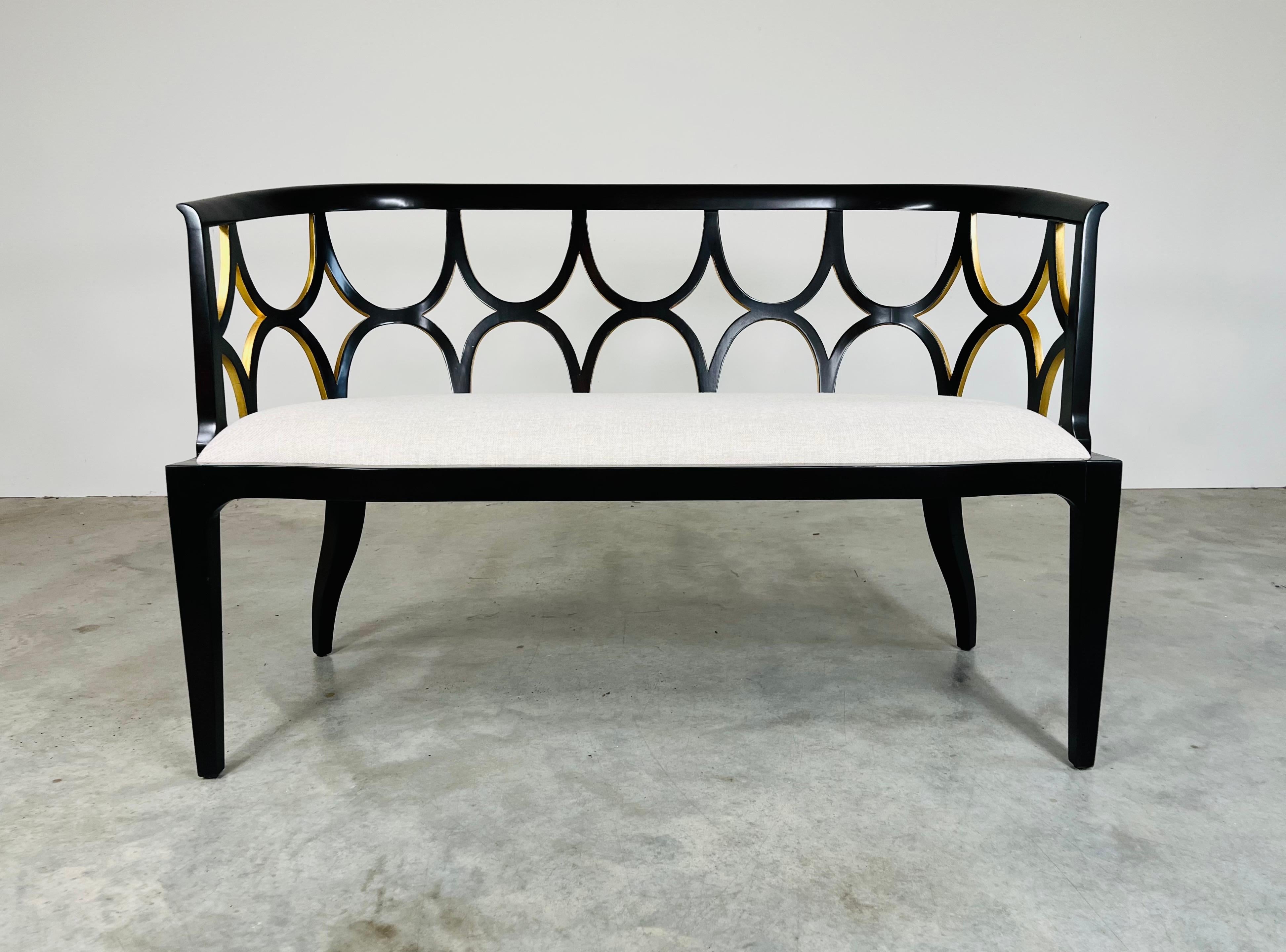An elegant ebonized mahogany settee having gold gilt details inside of the backrest arches with a neutral cushion seat by Theodore Alexander of High Point, N.C. In Like New condition having no marks, stains or damage of any kind. 

33x50x25” HWD SH