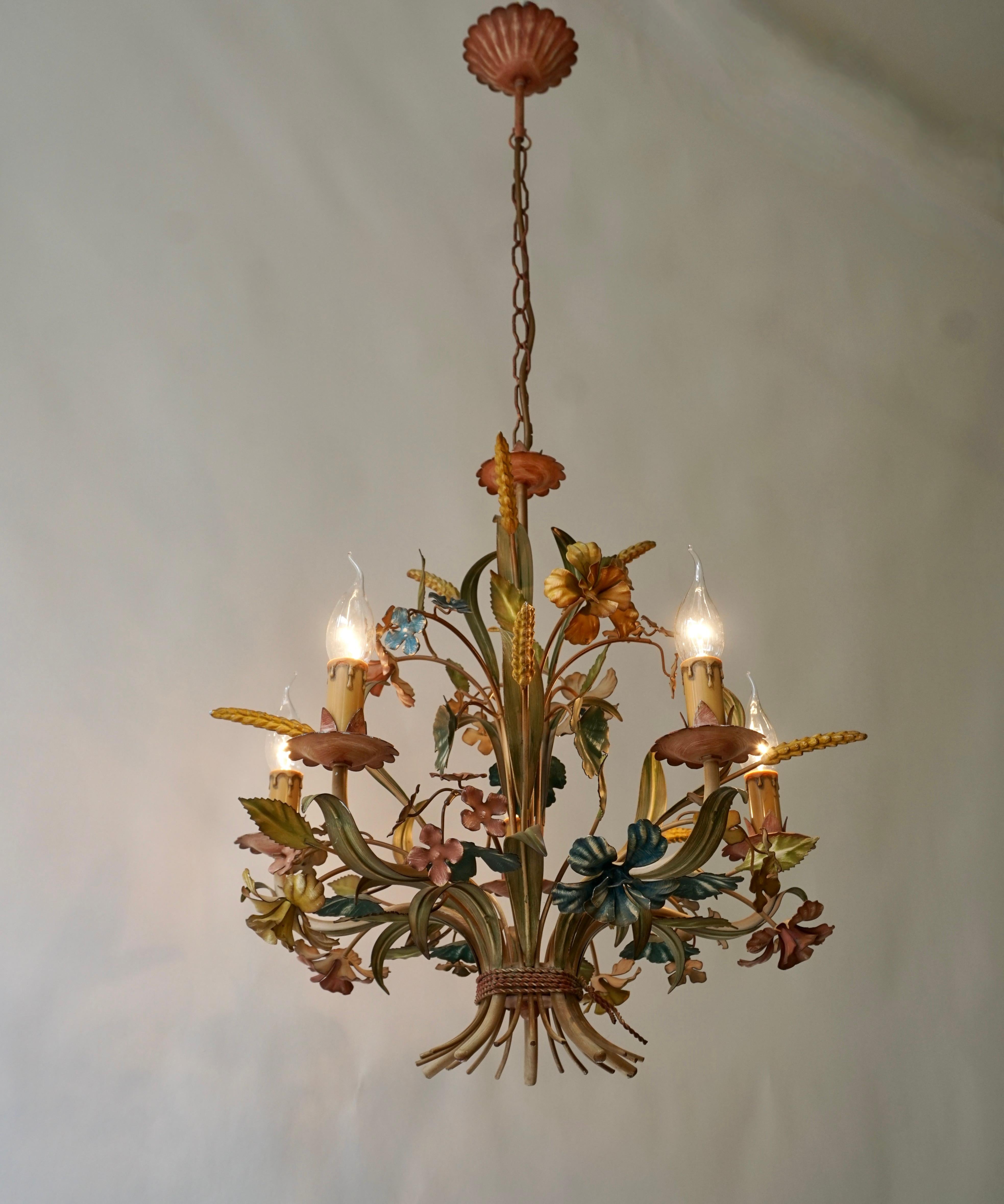 A large vintage tole five-light chandelier flower and leaf accents. Original paint finish in vibrant greens, turquoise and blue,white.

Diameter 19.6