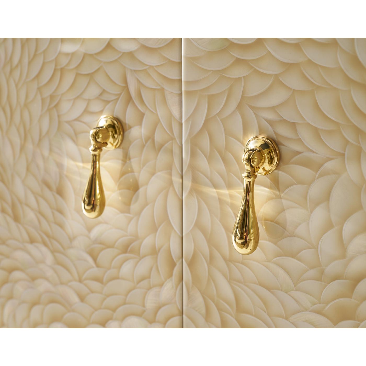 Two Door Cabinet is a shining example of luxury and artistry. Meticulously artisan made, this compact statement piece features hand-painted doors with a swirling, feather-like pattern that adds organic elegance and depth.

Polished brass trim and
