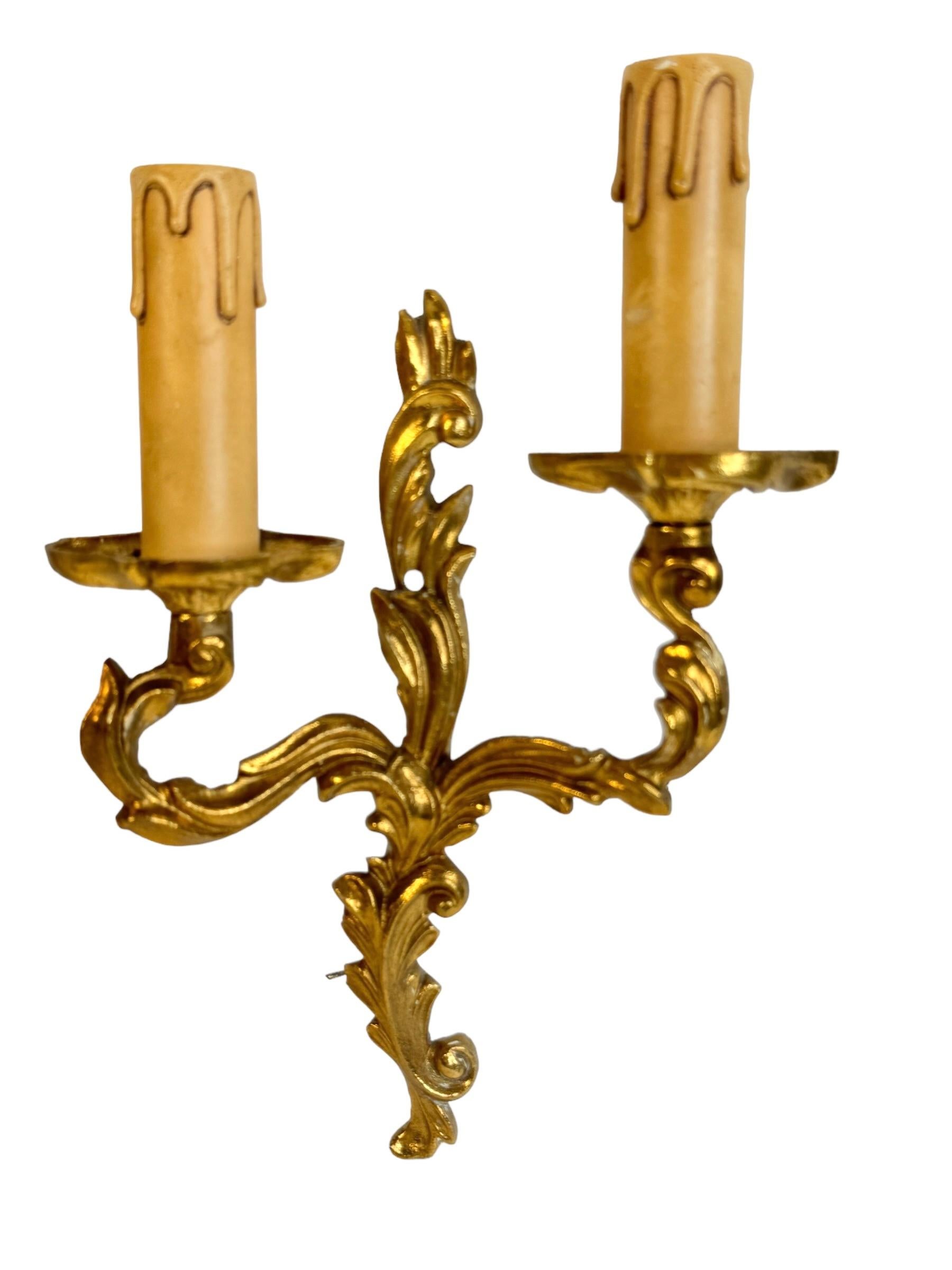 Paire d'appliques en laiton lourd de style Hollywood Regency du milieu du siècle dernier. Chaque luminaire nécessite deux ampoules candélabres européennes E14, chaque ampoule ayant une puissance maximale de 40 watts. Les appliques ont une belle