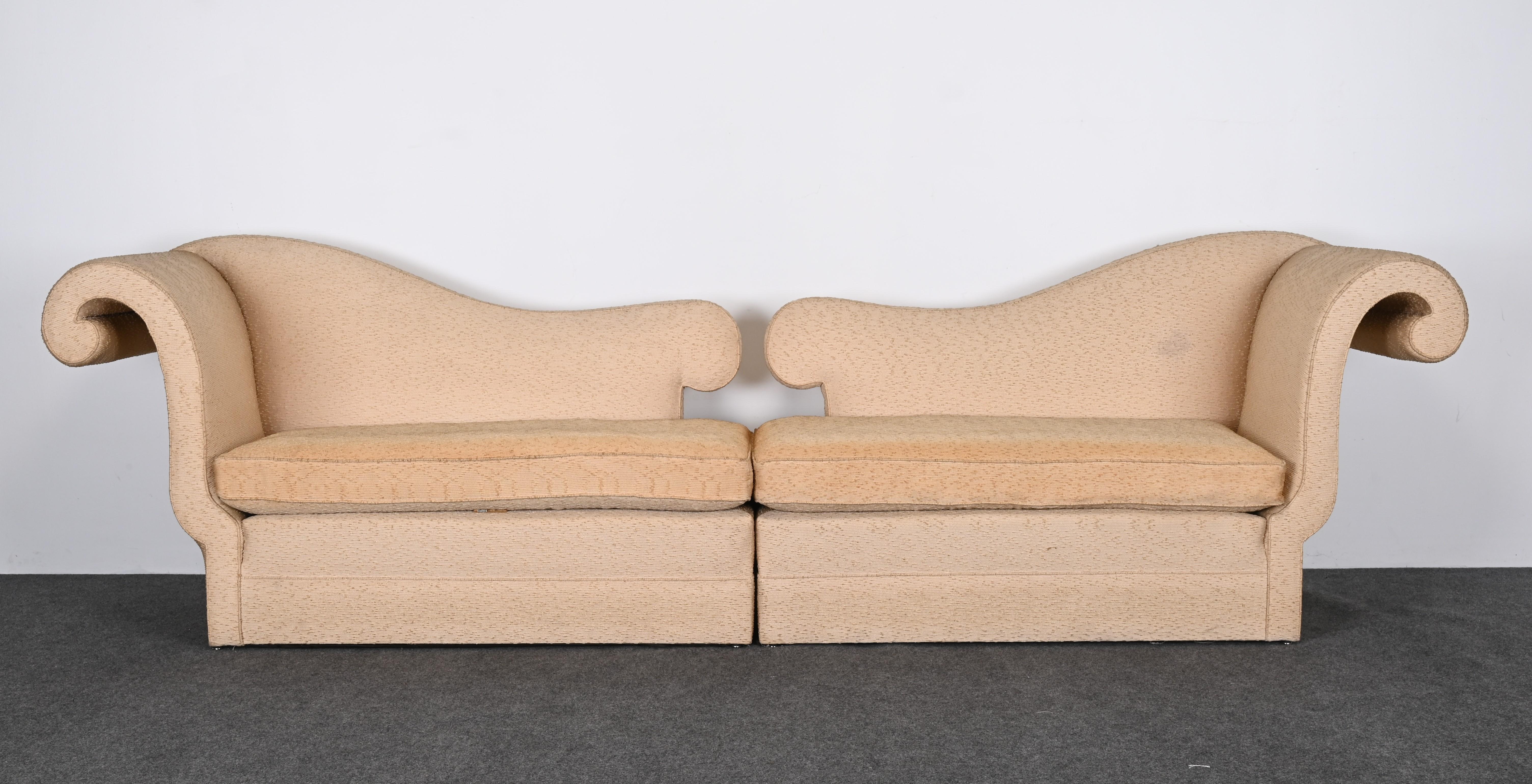 Ein zweiteiliges Designersofa mit gegenläufigen, geschwungenen Armlehnen im Hollywood-Regency-Stil. Dieses außergewöhnliche Sofa erinnert an die Entwürfe von Dorothy Draper aus den 1940er Jahren. Der Rahmen ist solide und strukturell gesund. Die