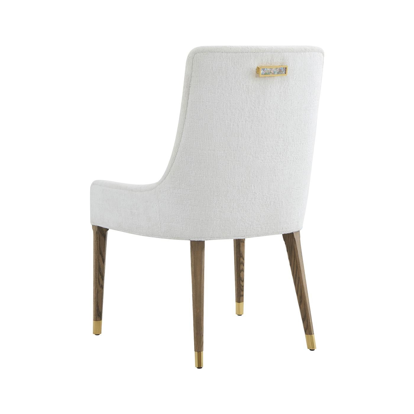 La sedia da pranzo imbottita dona un'elegante morbidezza a qualsiasi ambiente da pranzo. Lo schienale e la seduta imbottiti sono stati realizzati su misura per garantire comfort e stile, creando un profilo scultoreo raffinato e invitante.

Le gambe