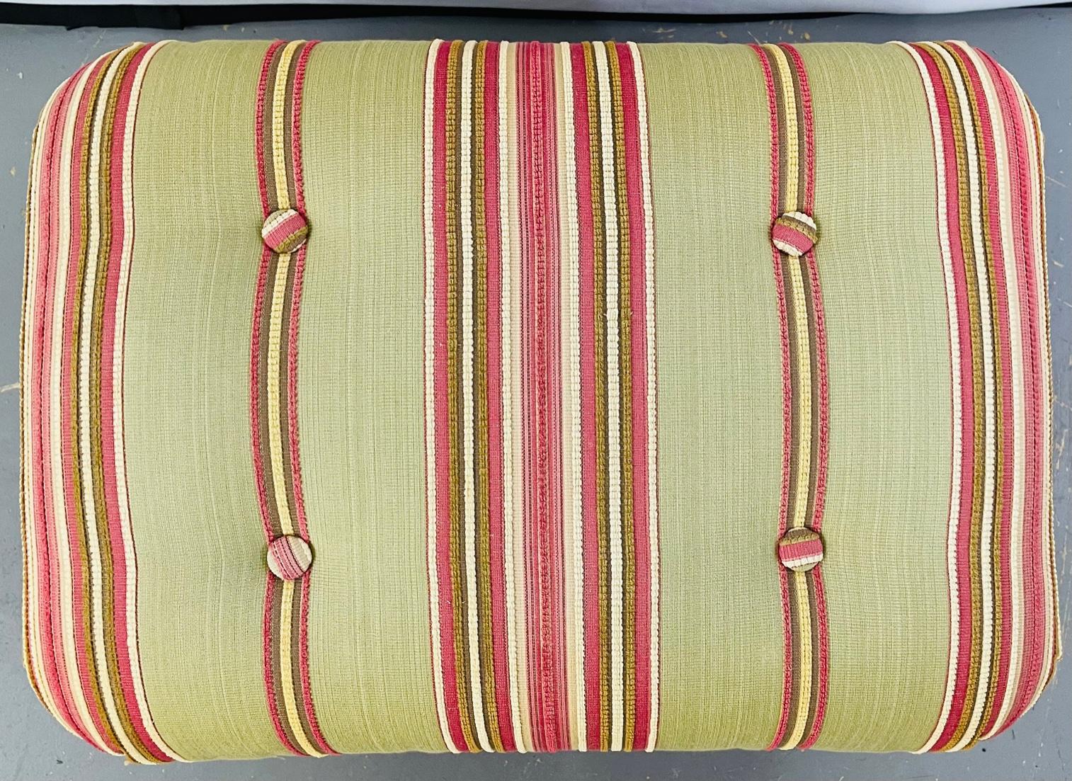 A Hollywood Regency finely upholstered tufted green and pink rectangular shaped foot stool or ottoman. The foot stool is finely decorated with tassels and standing on wooden feet. A classy and elegant addition to your living room or ready room to