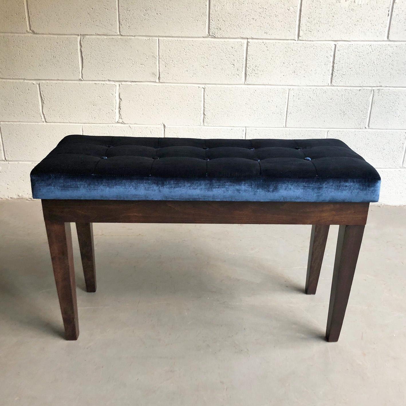 Hollywood Regency, piano storage bench features a walnut frame with a deep blue velvet tufted seat. The bench when hinged open is 34 inches height.
  