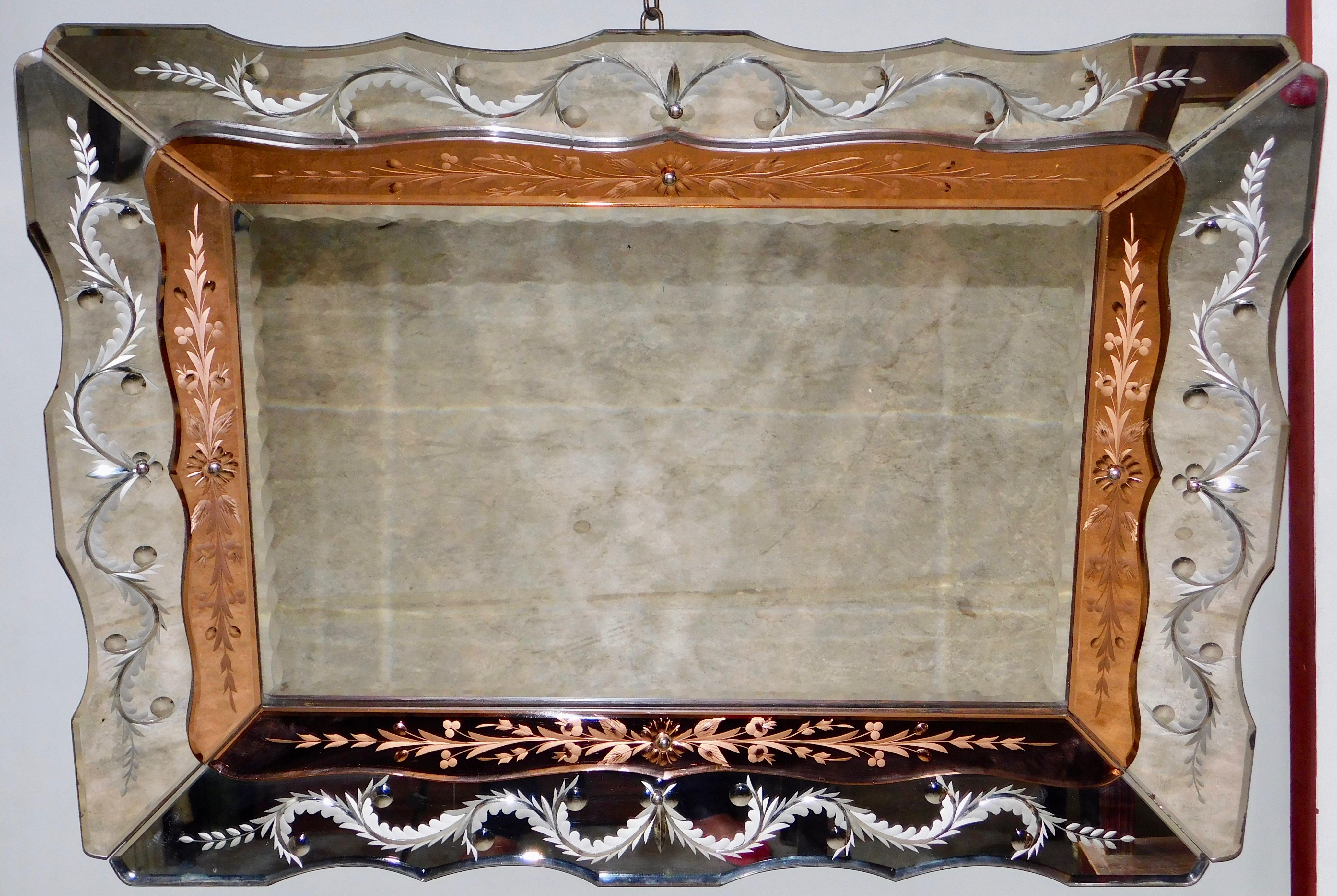 Elegant Venetian, circa 1940 Hollywood Regency mirror with reverse plume and starburst etched panels. The inner panels are a lovely peach color with delicate reverse etched design. The whole mirror is in very good condition retaining all the