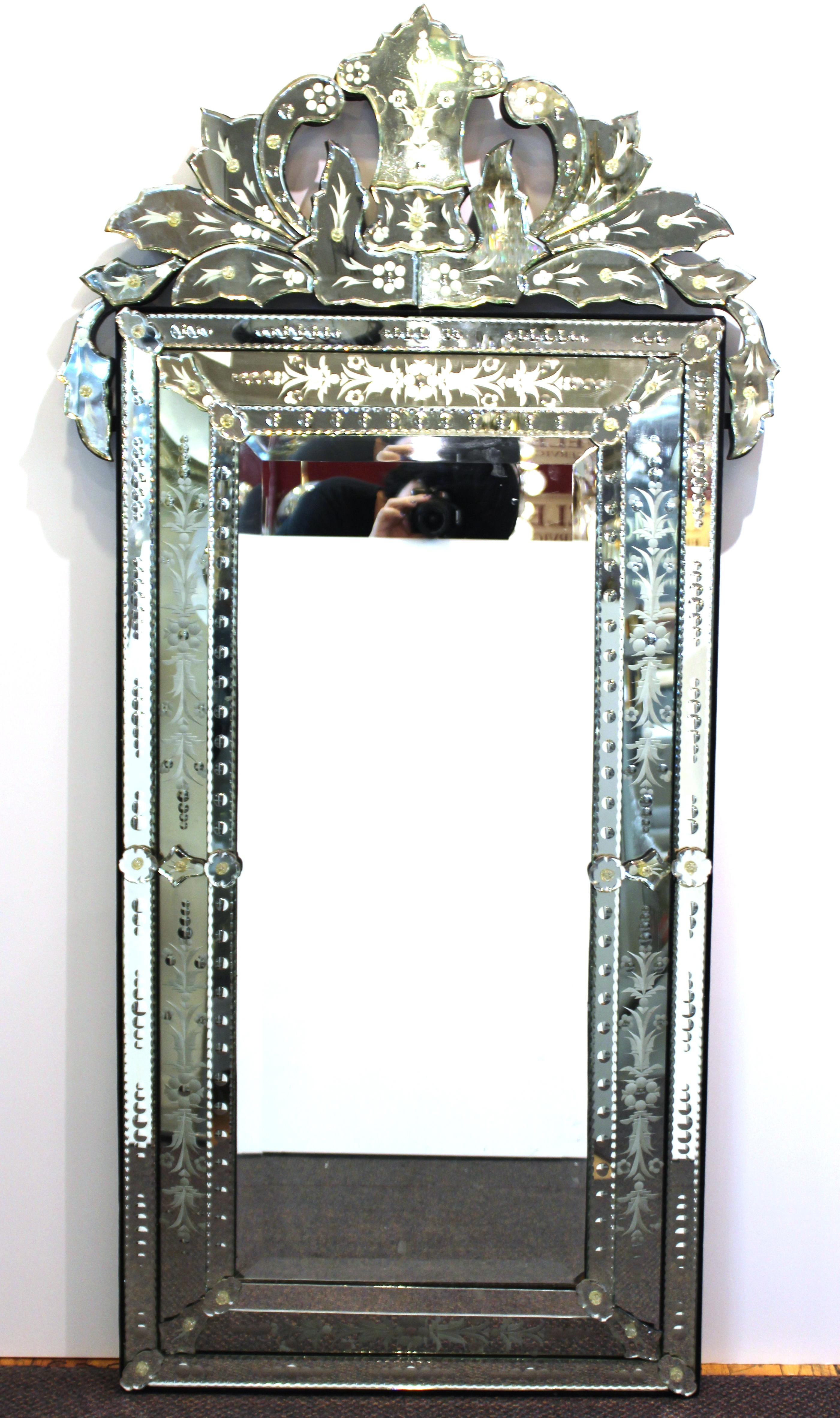 Hollywood Regency Venetian wall mirror, produced in Italy, circa 1940s, the crowned frame decorated with floral etching and scrolling glass panels. The mirror remains in great vintage condition, consistent with age and use.