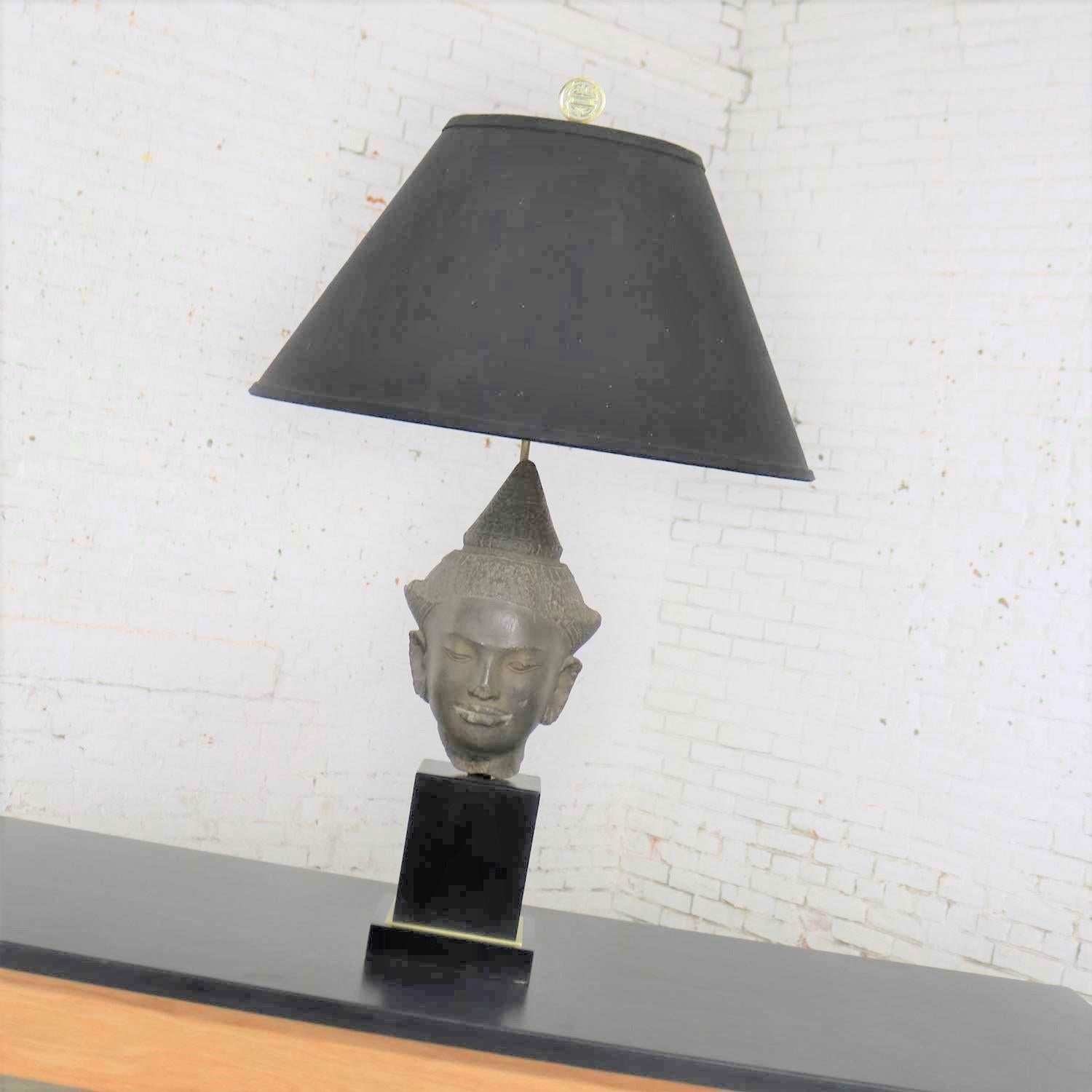 Handsome Hollywood Regency Buddha head table lamp by Paul Hanson. It is in fabulous restored condition including a new wiring. It is ready to plug in and use. The original vintage hard fabric shade is offered here and in good condition. However, we