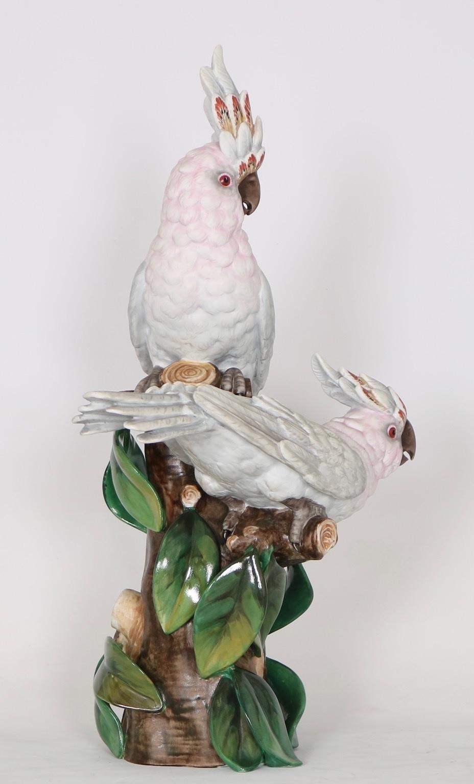 Hollywood Regency Portuguese bisque and majolica porcelain parrot figures made by Vista Alegre in Portugal in the early 20th century. The birds are perched in a tree marked on the bottom with a VA Vista Alegre mark and are in excellent vintage