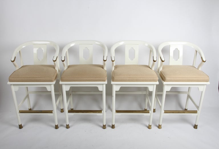 Hollywood Regency Style or Modern Ming Style set of four bar stools in white lacquer & brass details by Century Furniture Company. These stools are less common that the lounge chair version, often attributed to Mid-Century Modern Designer James