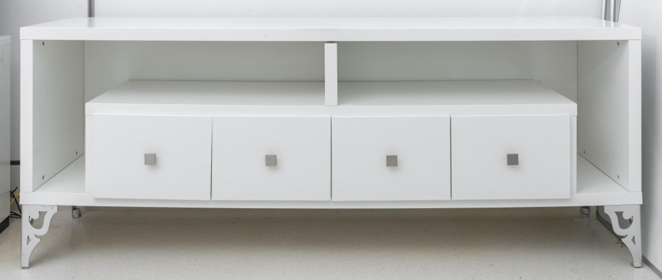 Hollywood Regency white lacquered side cabinet or credenza with four square drawers, each centering a square nickel pull, with two surrounding niches for storage, the whole on reticulated silvered cut-metal legs.
Dealer: S138XX.