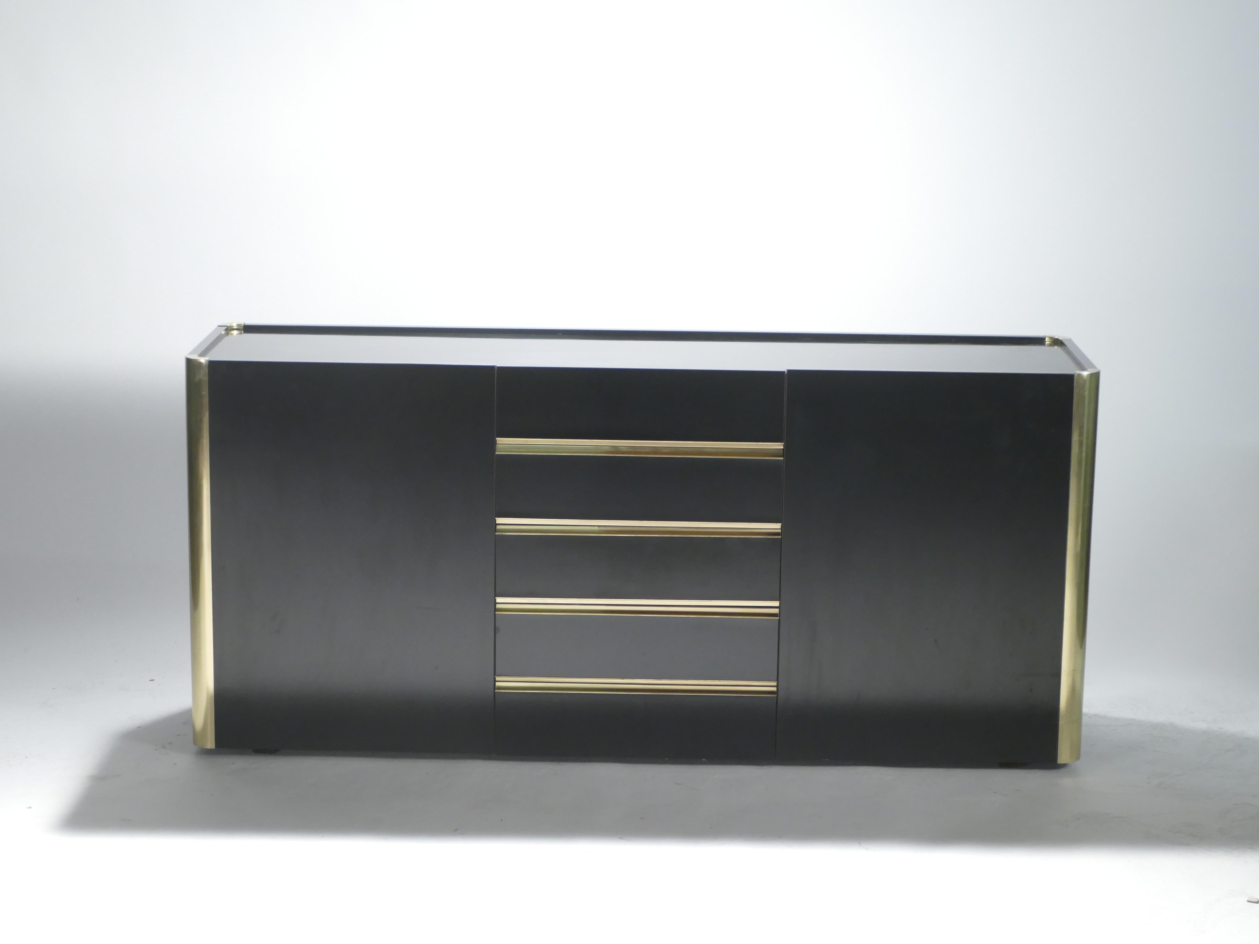 A timeless vintage piece, this midcentury sideboard feels imposing and glamorous, with thick, straight lines of brass adorning its exterior of reflective black lacquer. Made by renowned Italian designer Willy Rizzo for Mario Sabot, it’s consistent