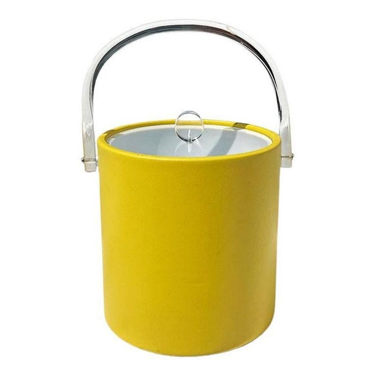 Una cubitera o enfriador de vino amarillo brillante y lucite Hollywood Regency. Este cubo parece salido directamente de Palm Royale. Es redonda y está recubierta de una tela de piel sintética de color amarillo brillante. Tiene un asa giratoria de
