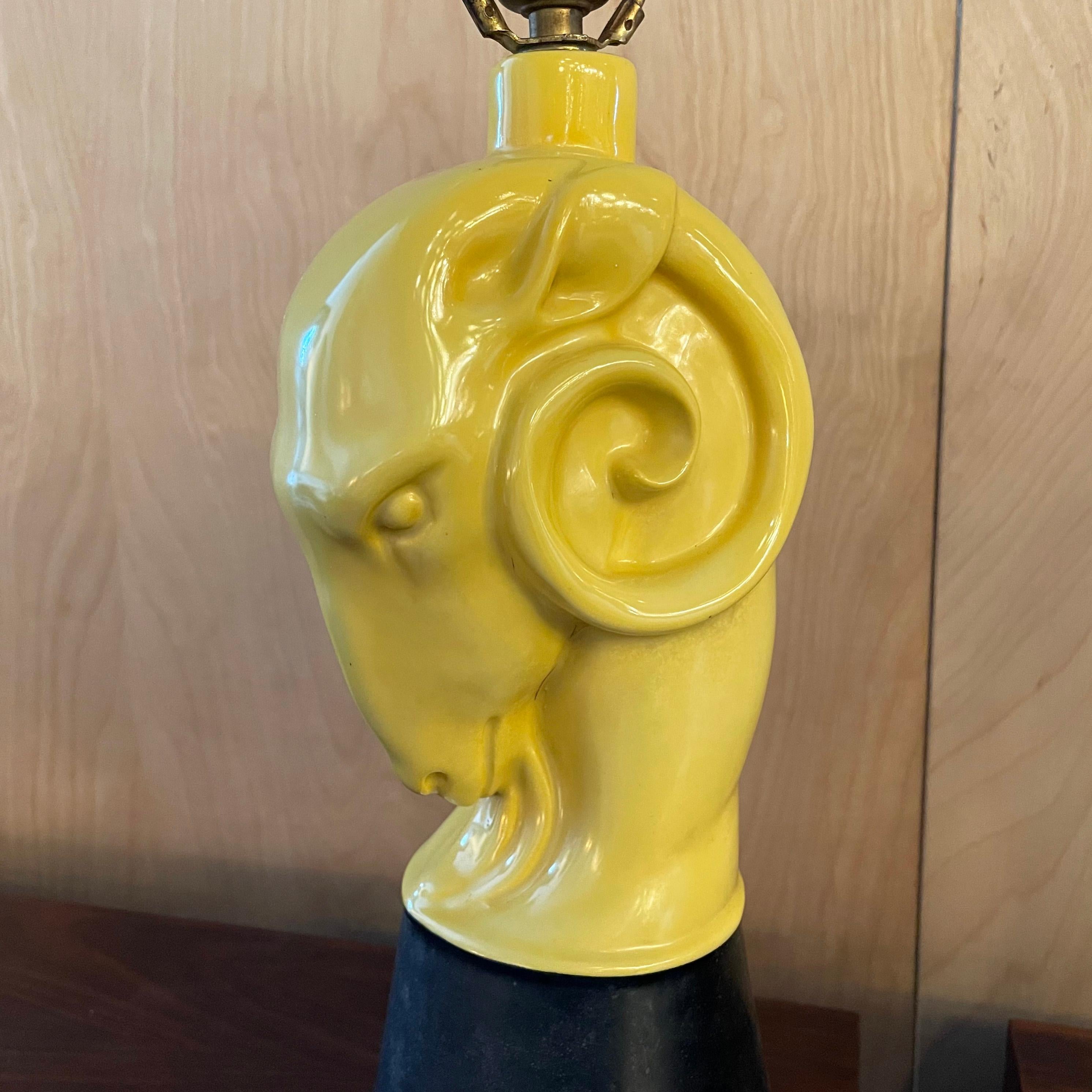 Midcentury, Hollywood Regency, high-glaze, yellow ceramic, figurative, ram's head table lamp with black matte ceramic base. A second ram's head table lamp is available in white, listed separately. The lamp is not should with a shade.
  