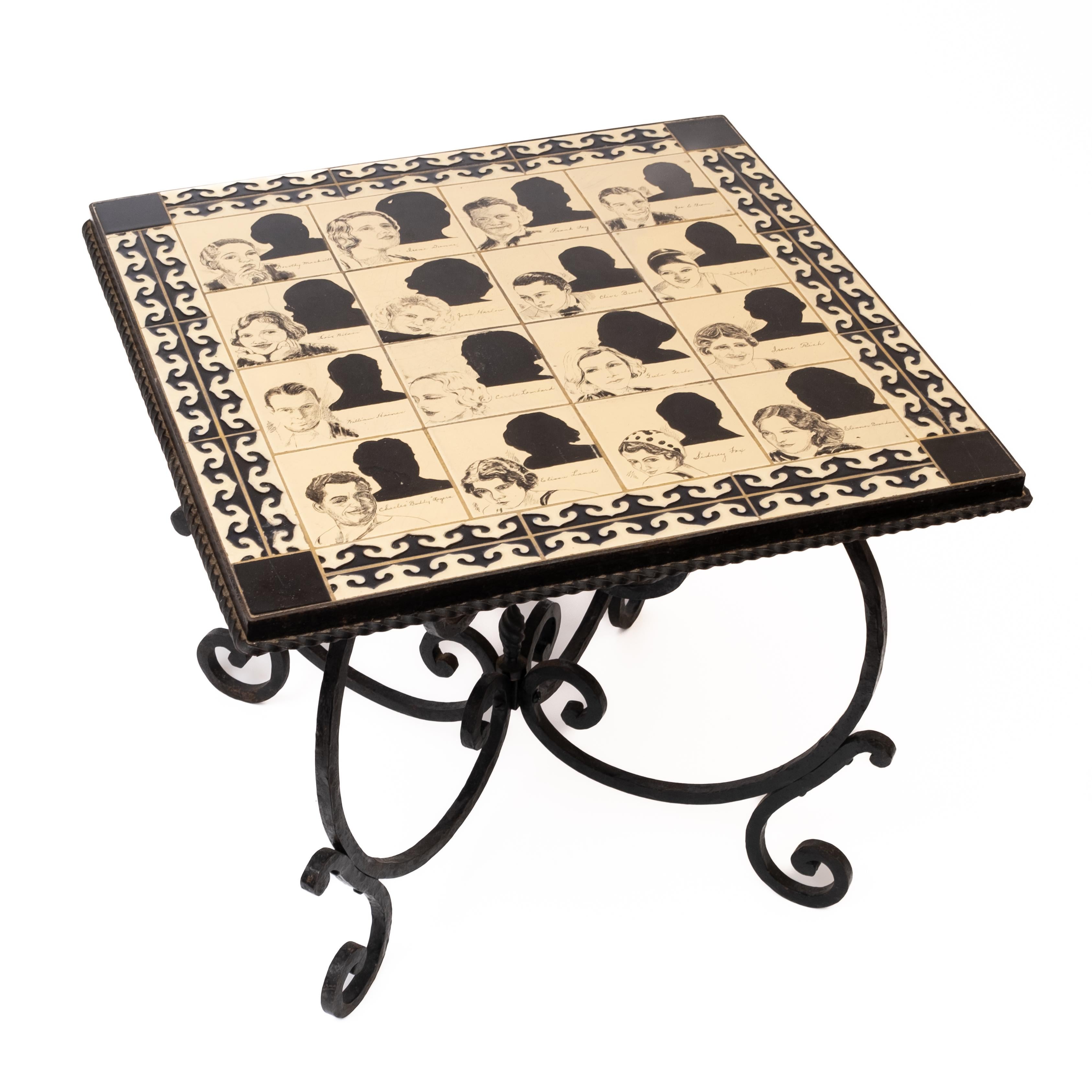 Hand painted vintage tile top wrought iron side depicting hollywood notables. Vintage tile-top, wrought iron side/cocktail table. A unique nostalgic tribute to the screen stars of the pre-World War II entertainment industry. No visible