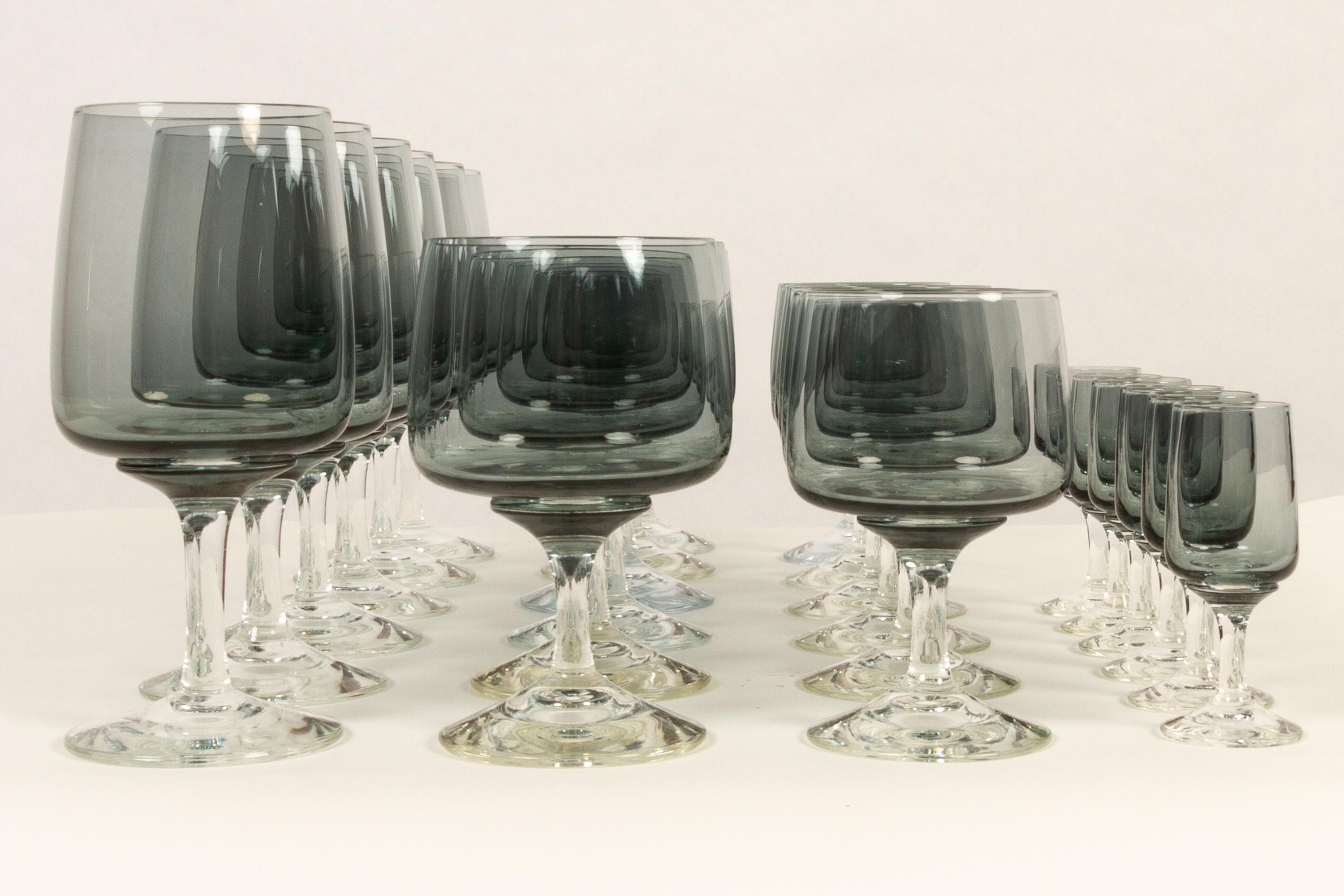 Holmegaard Atlantic drinking glasses 1960s set of 24.
Set of 24 beautiful mouth-blown vintage drinking glasses from Danish glasswork Holmegaard designed by Per Lütken in 1962. The top of the glasses are tinted in a bluish grey, base in clear glass.
