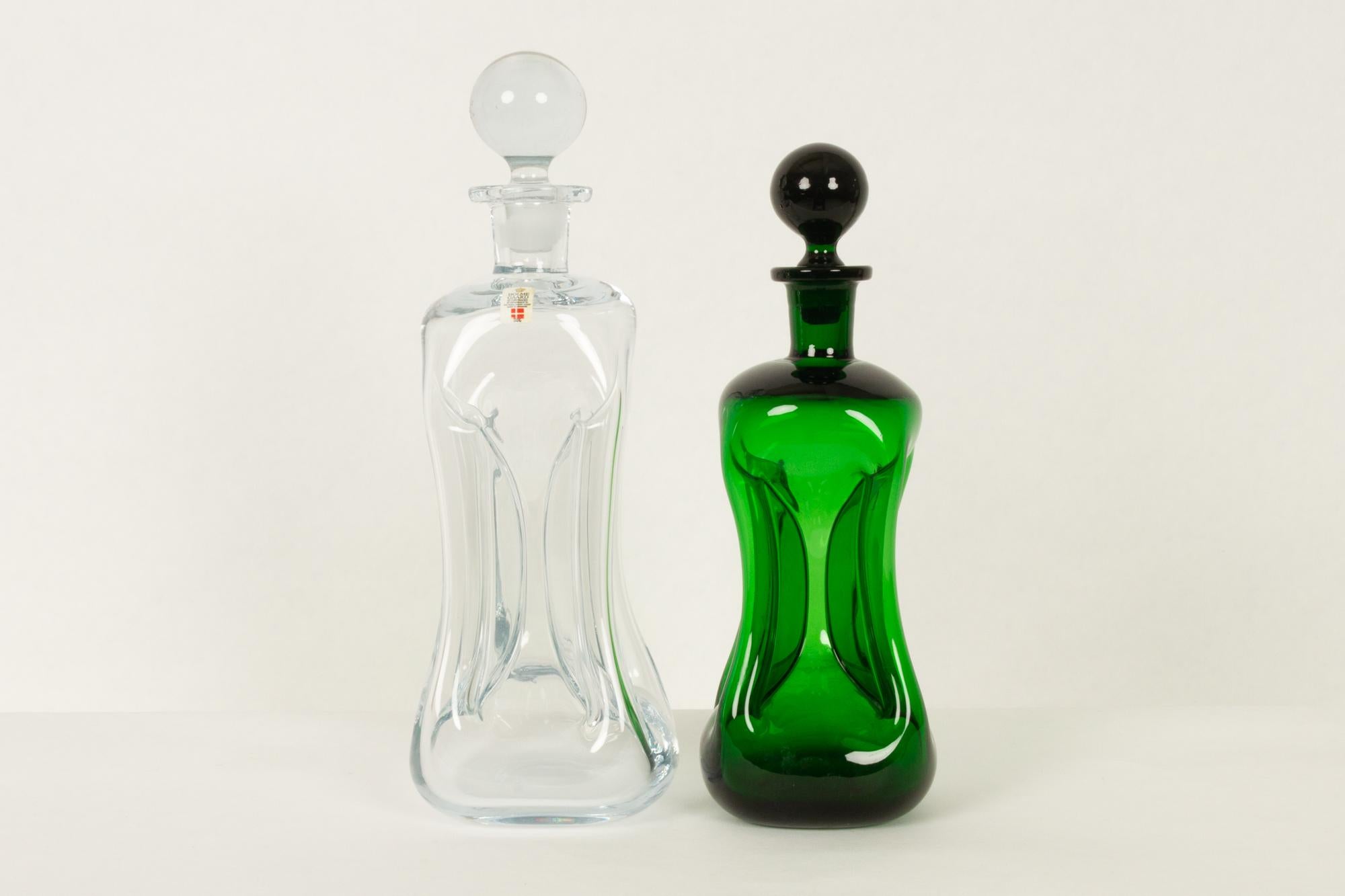 Holmegaard cluck cluck decanters by Jacob E. Bang, 1960s
Set of two Mid-Century Modern hand blown decanters from Danish glassworks Holmegaard. The bottles has got the name from the sound they make when pouring.
One large (31.5cm) in clear glass