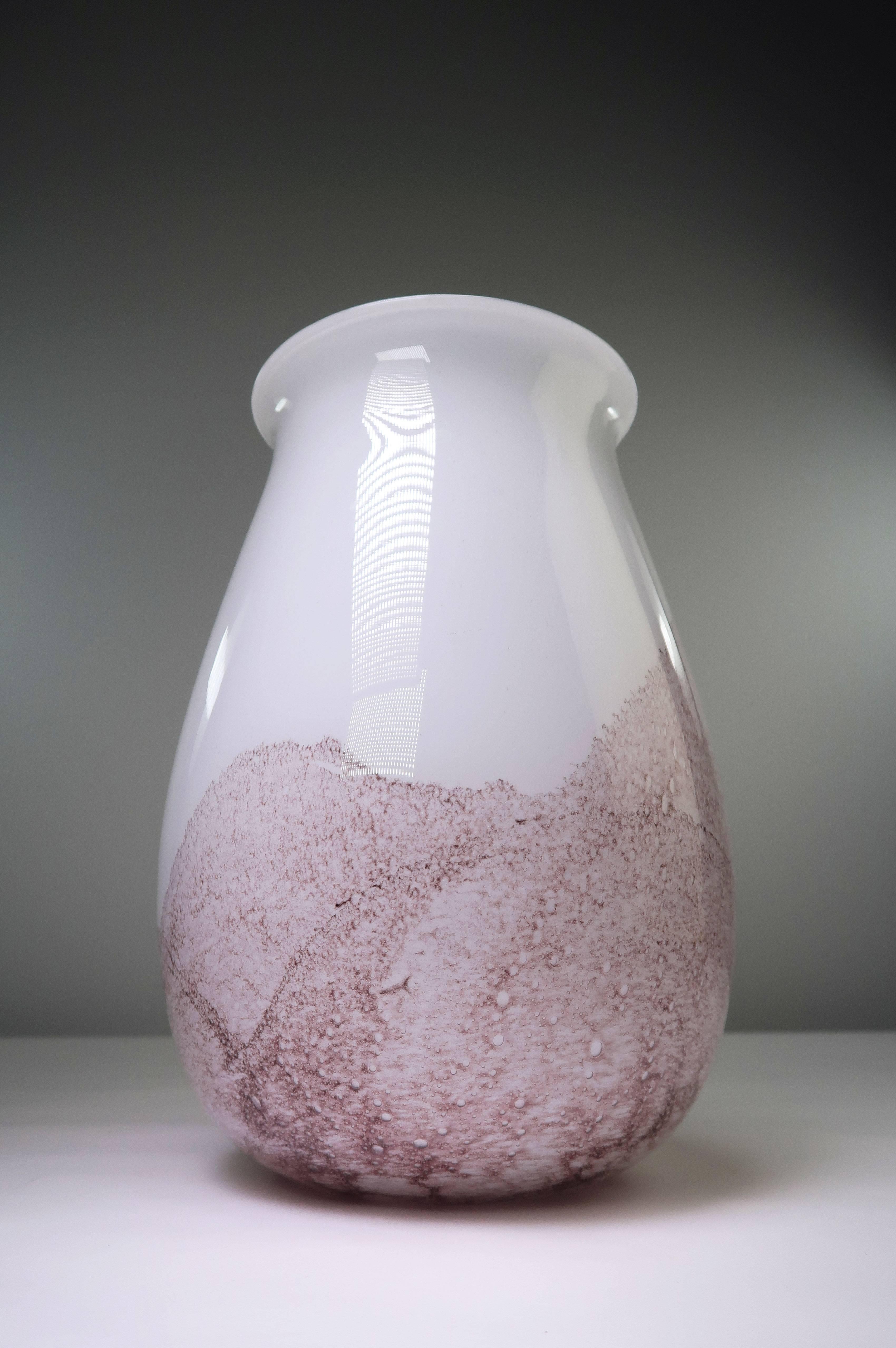 Danish modern mouth blown art glass vase with mulberry colored bubbly landscape like pattern on opaline white glass. Manufactured by Danish glassworks Holmegaard in the 1960s. Excellent, seemingly nused condition.
Denmark, 1960s. 

The history of