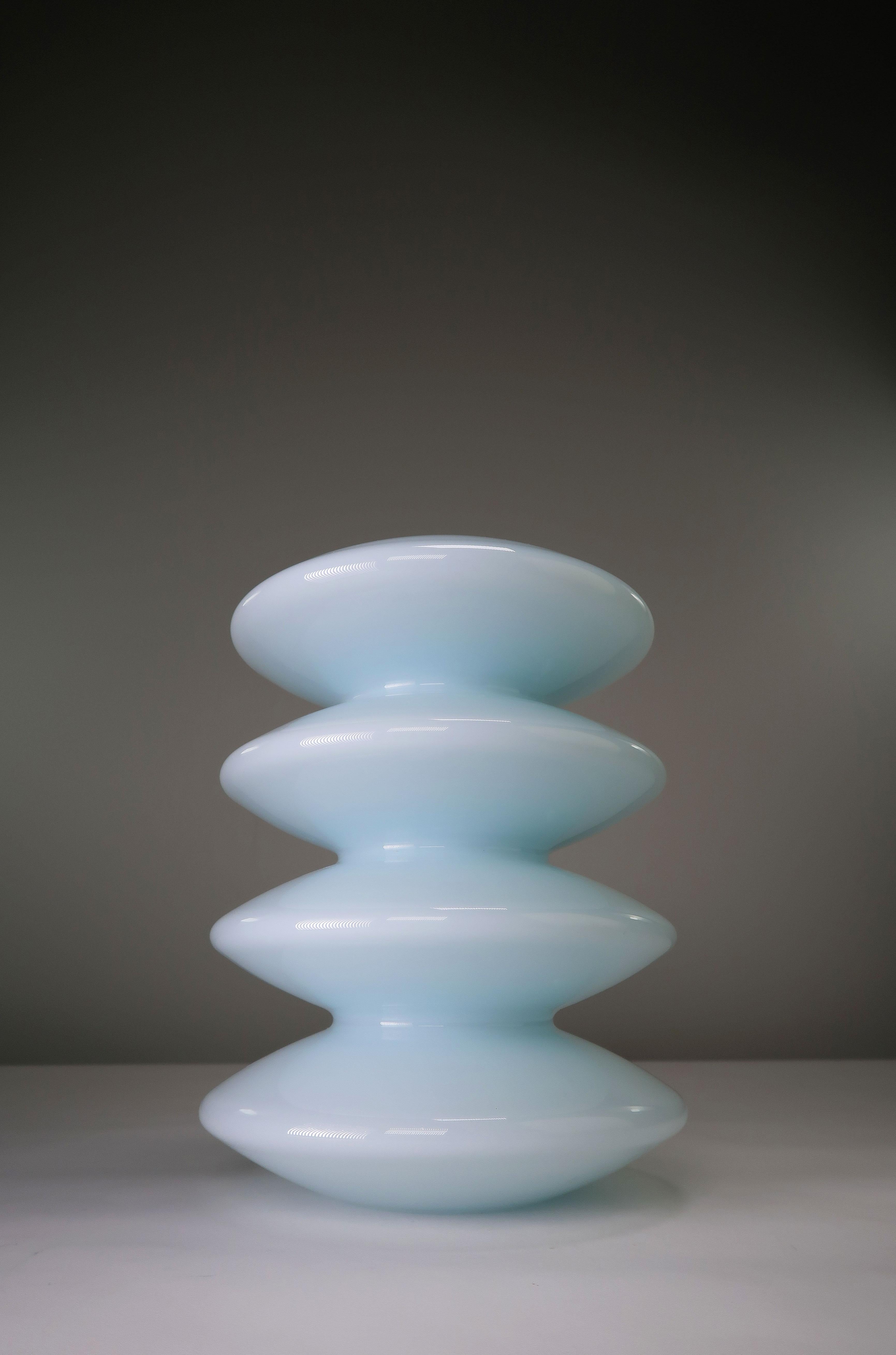 Beautiful Danish light blue tiered glass vase by contemporary designer Peter Svarrer who is nicknamed the Master of Light because of the way his glass designs captures and reflects light. The vase was manufactured in the Danish town of Naestved in