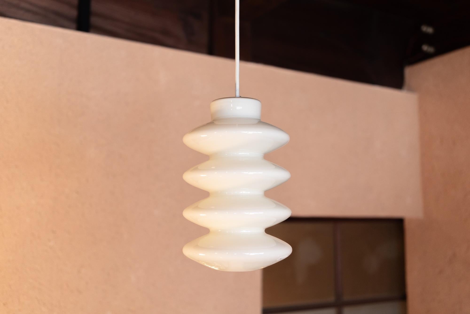Lampada a sospensione progettata da Peter Svarrer per Holmegaard nel 2000. Questa lampada danese è realizzata in vetro opalino. La lampada è in ottime condizioni, senza danni o crepe.