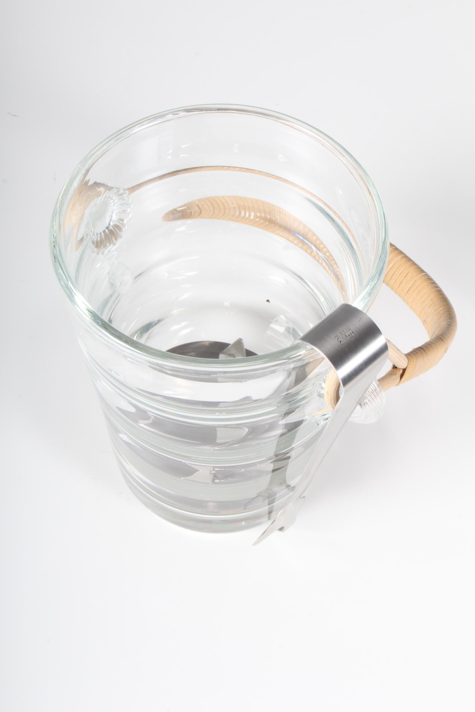 Holmegaard ice bucket in glass with cane handle.

Made by Holmegaard in the 1960s.