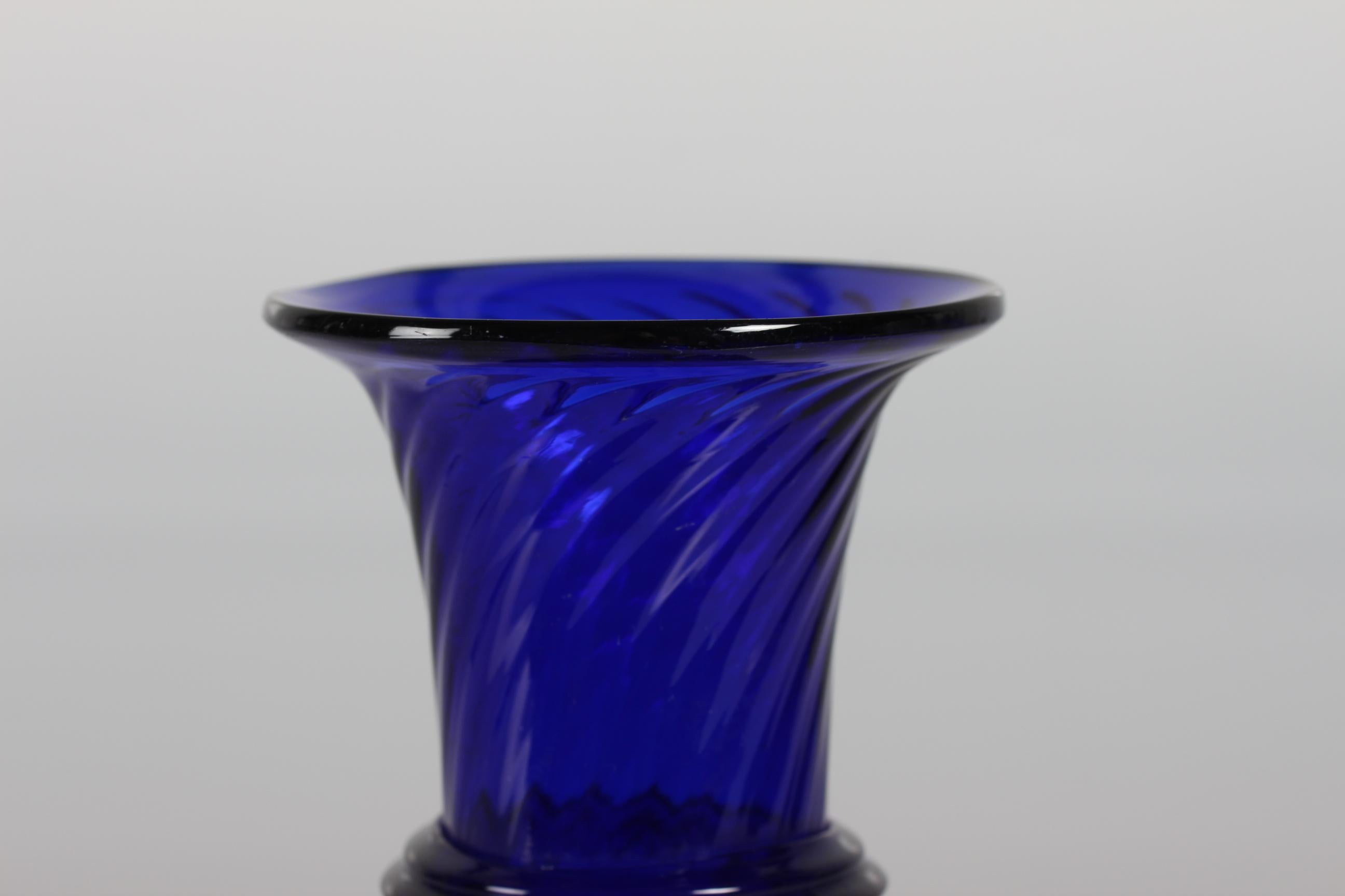 Old Danish hyacinth glass or vase made by Holmegaard or Kastrup glassworks, circa 1900.

The hyacinth glass is made of dark blue mouth blown glass and it has a elegant baluster form on a small foot. There is a lightly twisted pattern in the glass