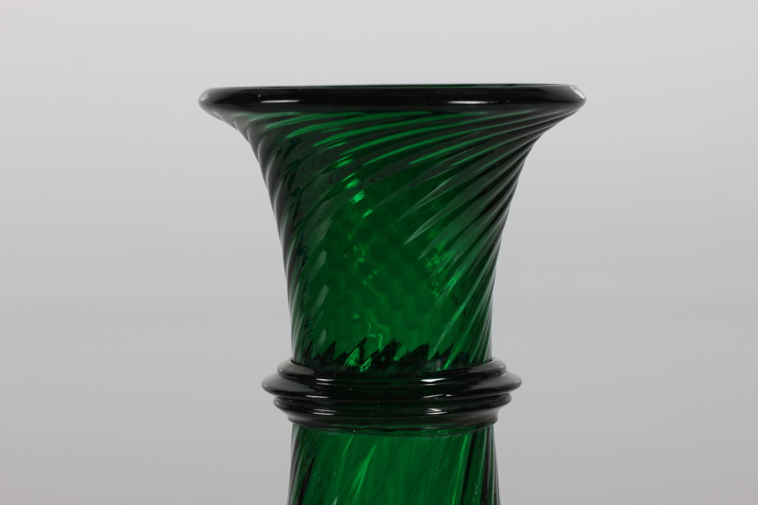 Old Danish hyacinth glass or vase from Holmegaard or Kastrup glassworks, circa 1900.

The hyacinth glass is made of dark green mouth blown glass and it has a elegant baluster form on a small foot. There is a lightly twisted pattern in the glass