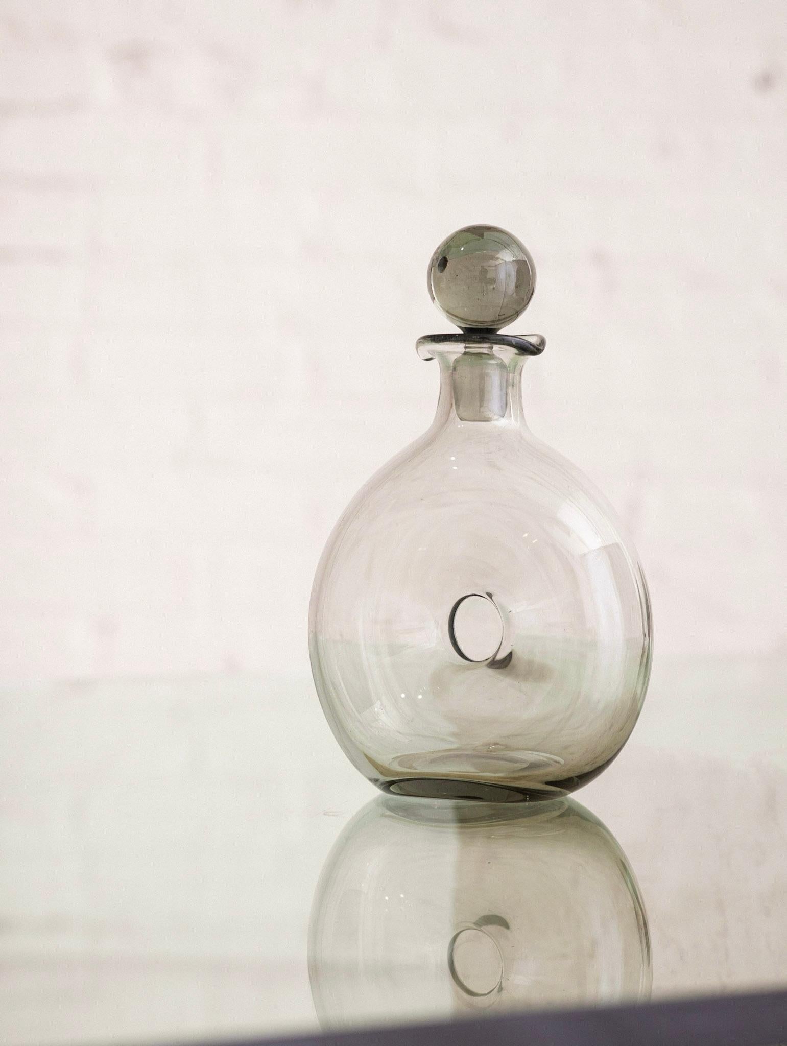 Mid Century blown glass “Danica” decanter by Holmegaard. Sculptural donut form. Vessel connects at center so that liquid wraps around the sides.