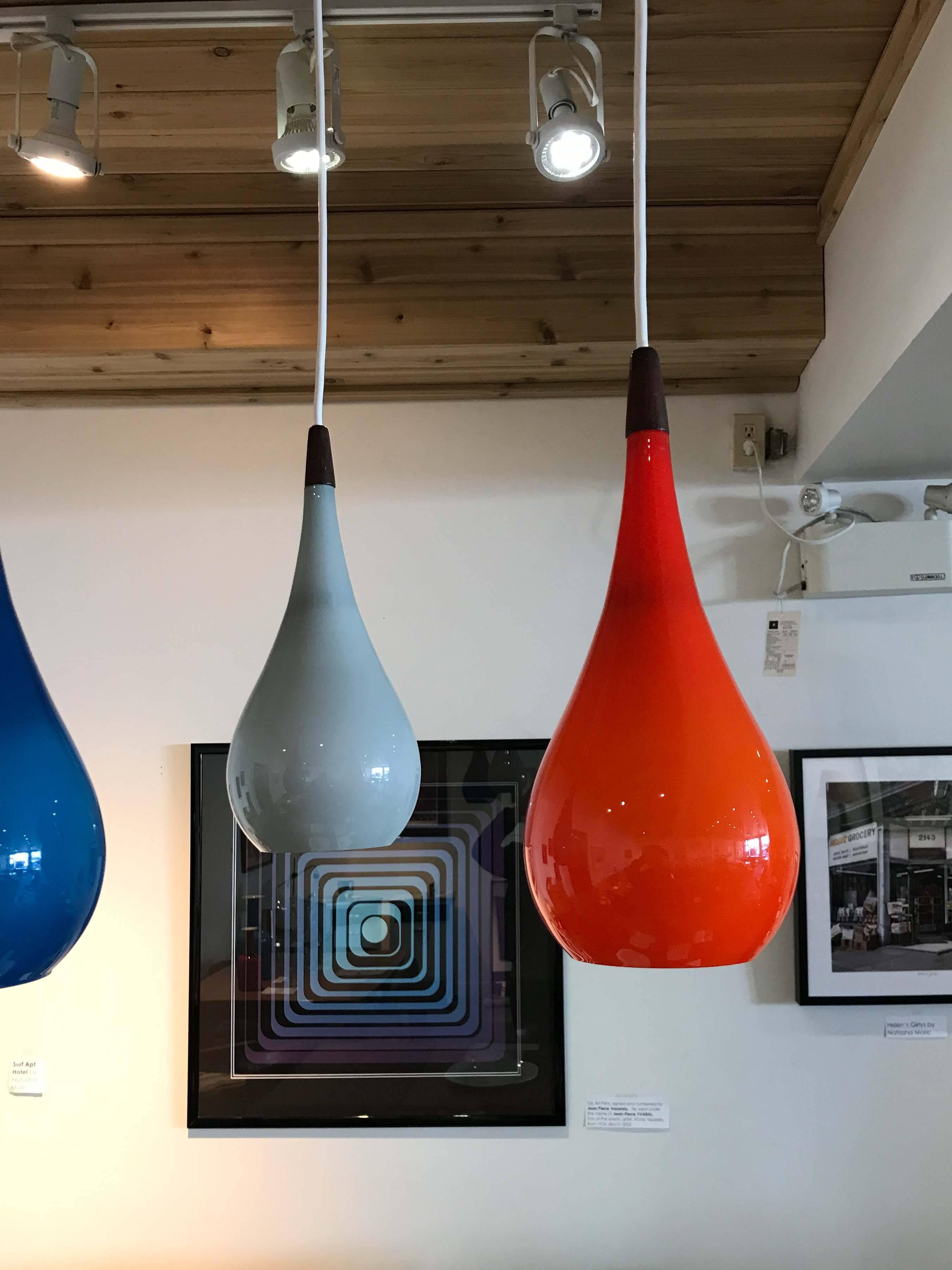 A colorful Holmegaard chandelier with tear-drop glass shades hung on a teak frame. The height of each shade is adjustable.

Great original condition, blue shade has a small 