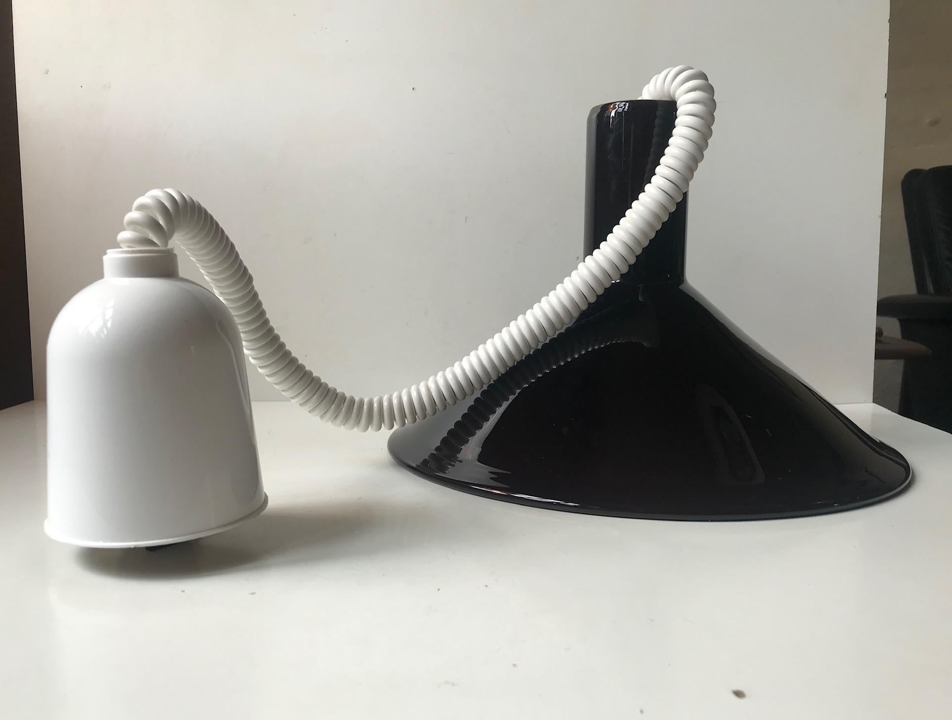Di colore nero all'apparenza, questa lampada a sospensione in vetro opalino e melanzana si trasforma in un viola intenso una volta coperta. È stata progettata da Michael Bang nel 1972 e prodotta da Holmegaard in Danimarca fino al 1980. Questa