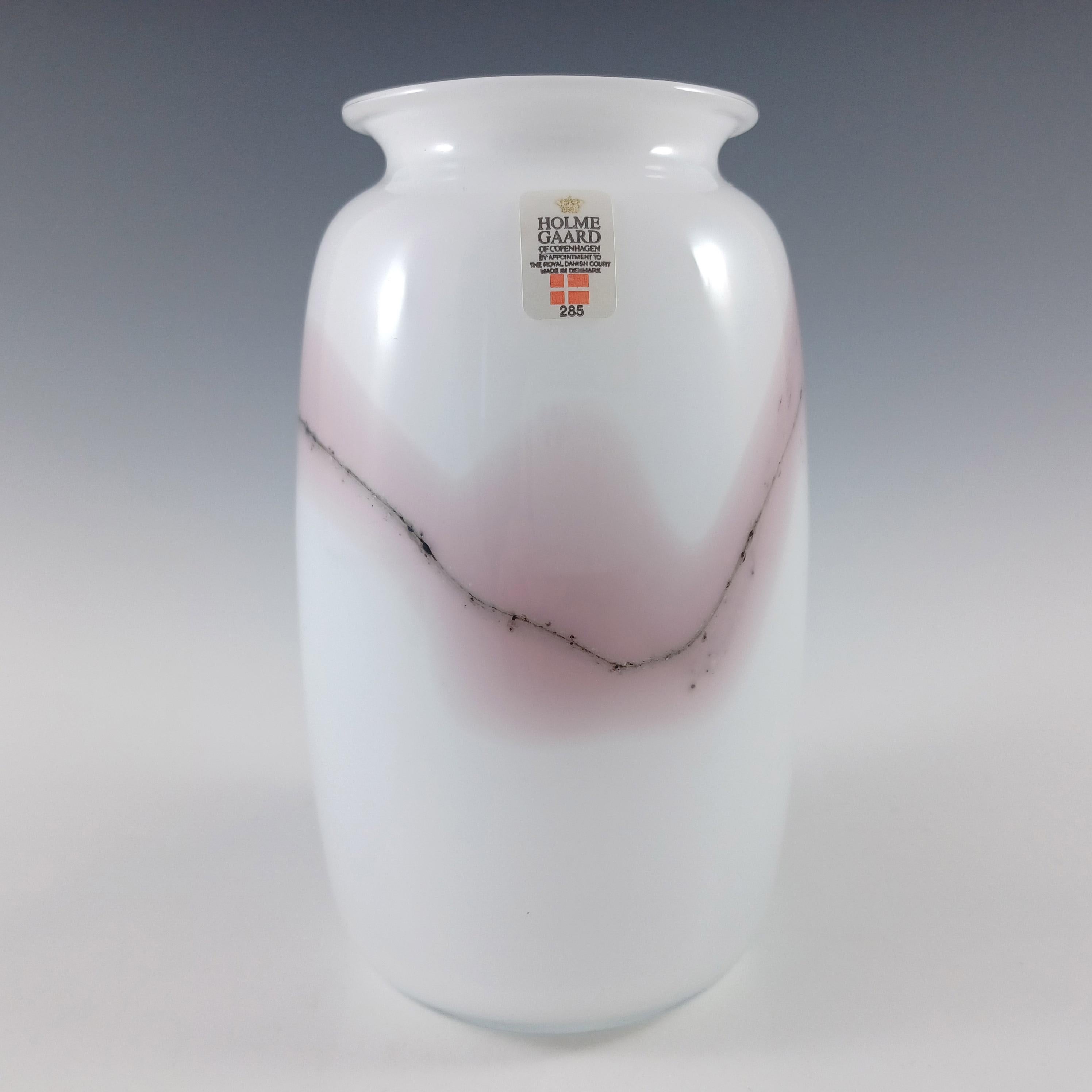 Uno splendido vaso scandinavo in vetro bianco opaco con striature viola e nere. Prodotto dalla danese Holmegaard e disegnato da Michael Bang, fa parte della sua linea Sakura. Porta ancora l'etichetta originale della fabbrica.

Dimensione
Misura